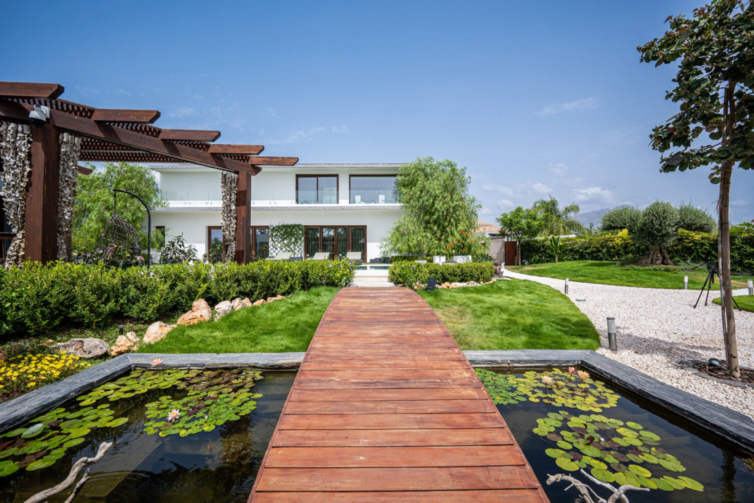 Villa TrueLove is a six-bedroom, five-bathroom luxury villa in the heart of Benahavís. It offers stunning mountain and garden views, combining modern technology with natural design. The home features a seamless connection between indoor and outdoor living