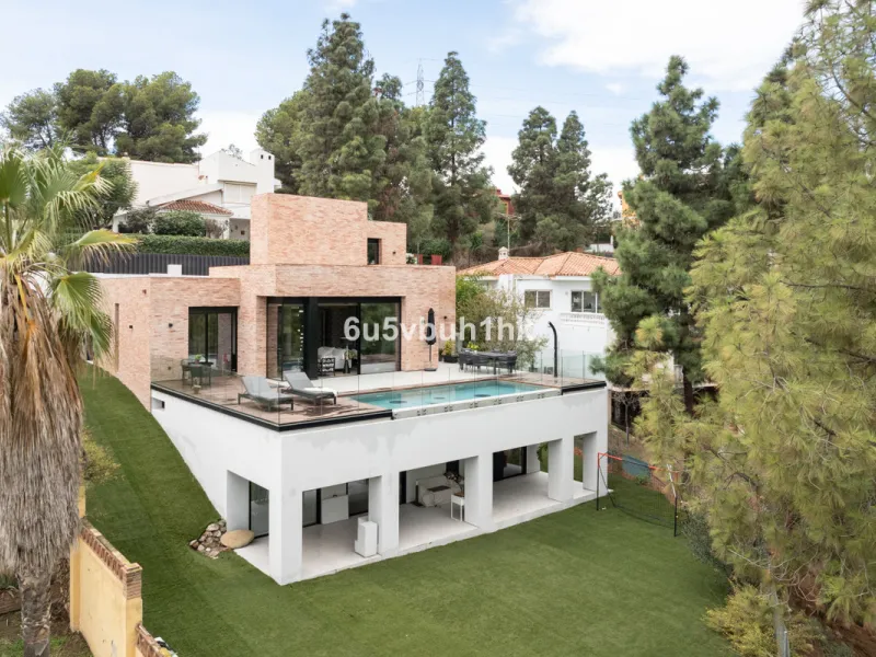 Exquisite modern villa, a newly built family home that perfectly blends contemporary design with comfort and convenience. Nestled in the desirable neighborhood of El Atabal, Malaga, this three-story residence offers breathtaking sea and mountain views fro