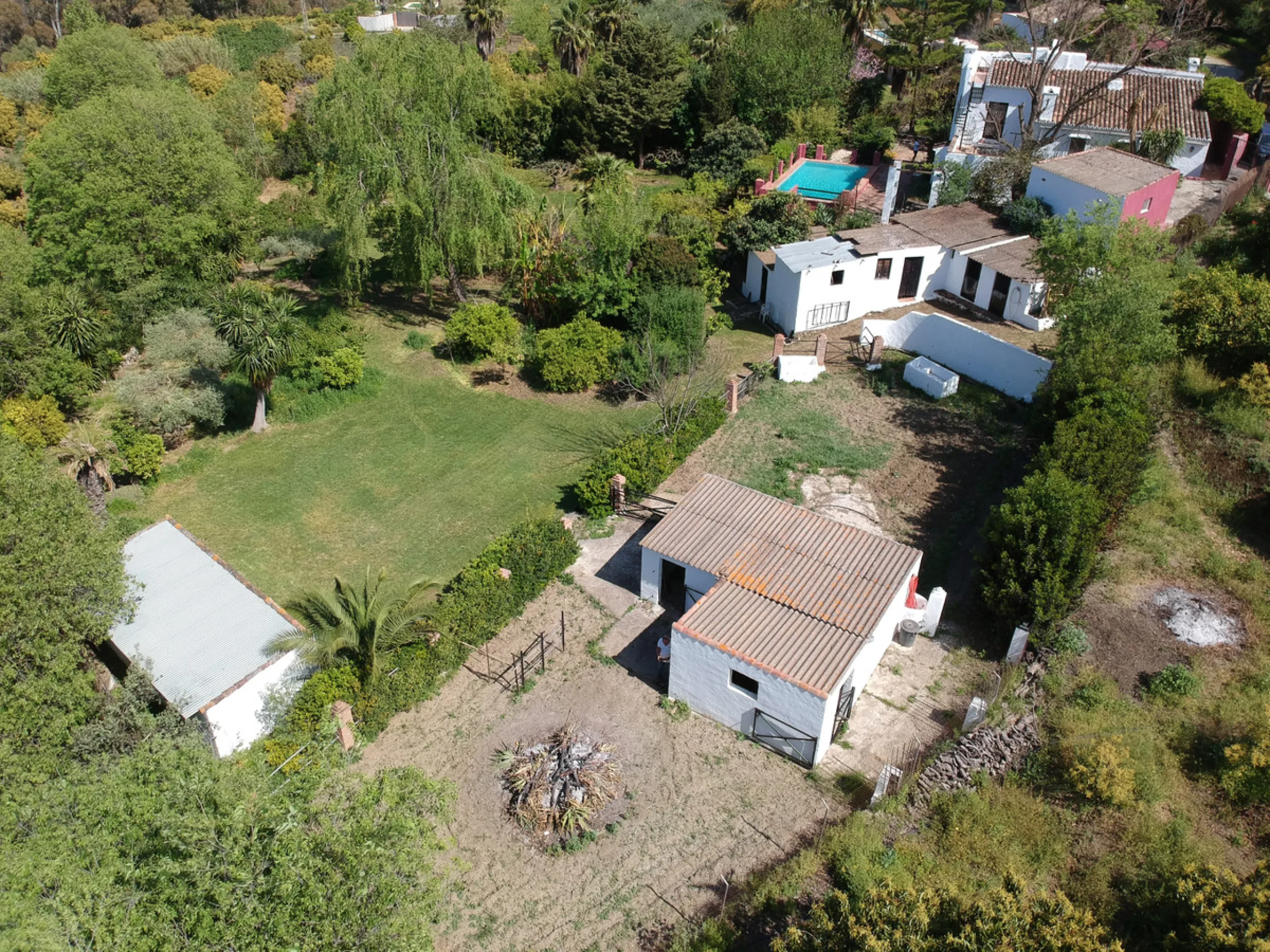 This hidden gem is nestled in a green oasis of nearly 4000m2, located 5 km from the lively village of Alhaurin el Grande, 20 km from the beaches of La Cala de Mijas, and 30 km from Malaga airport. Behind the walls of this historic estate lies a verdant wo