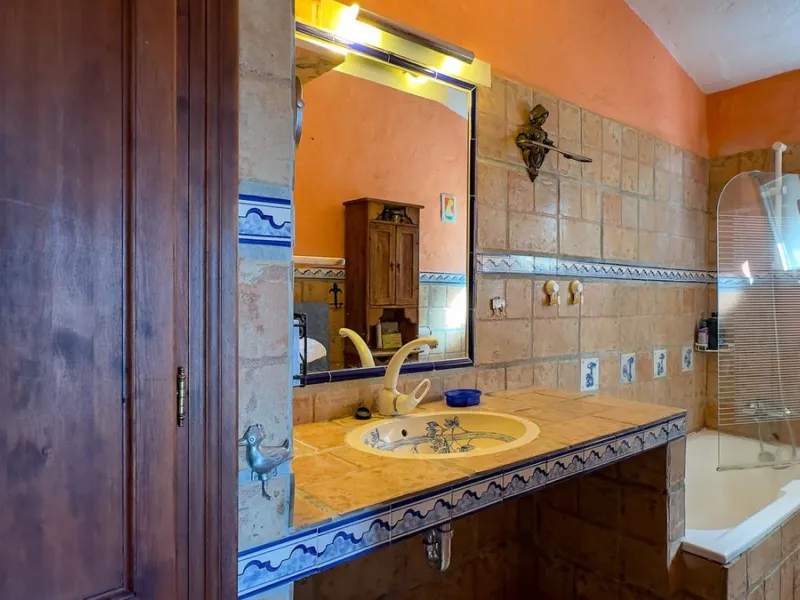This hidden gem is nestled in a green oasis of nearly 4000m2, located 5 km from the lively village of Alhaurin el Grande, 20 km from the beaches of La Cala de Mijas, and 30 km from Malaga airport. Behind the walls of this historic estate lies a verdant wo