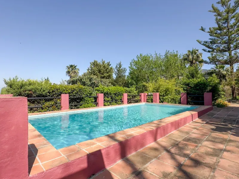 This hidden gem is nestled in a green oasis of nearly 4000m2, located 5 km from the lively village of Alhaurin el Grande, 20 km from the beaches of La Cala de Mijas, and 30 km from Malaga airport. Behind the walls of this historic estate lies a verdant wo