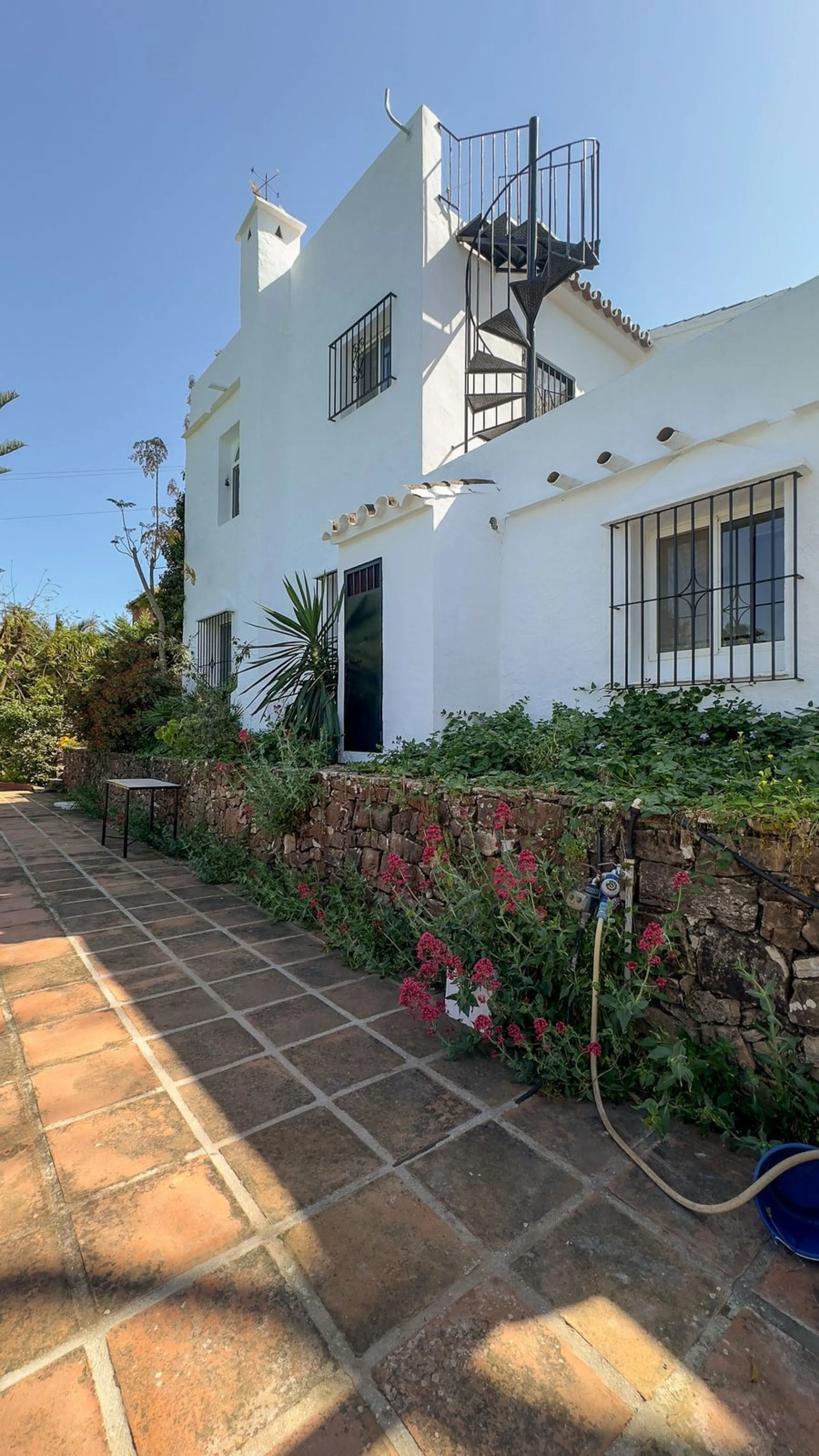 This hidden gem is nestled in a green oasis of nearly 4000m2, located 5 km from the lively village of Alhaurin el Grande, 20 km from the beaches of La Cala de Mijas, and 30 km from Malaga airport. Behind the walls of this historic estate lies a verdant wo