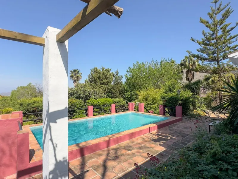 This hidden gem is nestled in a green oasis of nearly 4000m2, located 5 km from the lively village of Alhaurin el Grande, 20 km from the beaches of La Cala de Mijas, and 30 km from Malaga airport. Behind the walls of this historic estate lies a verdant wo