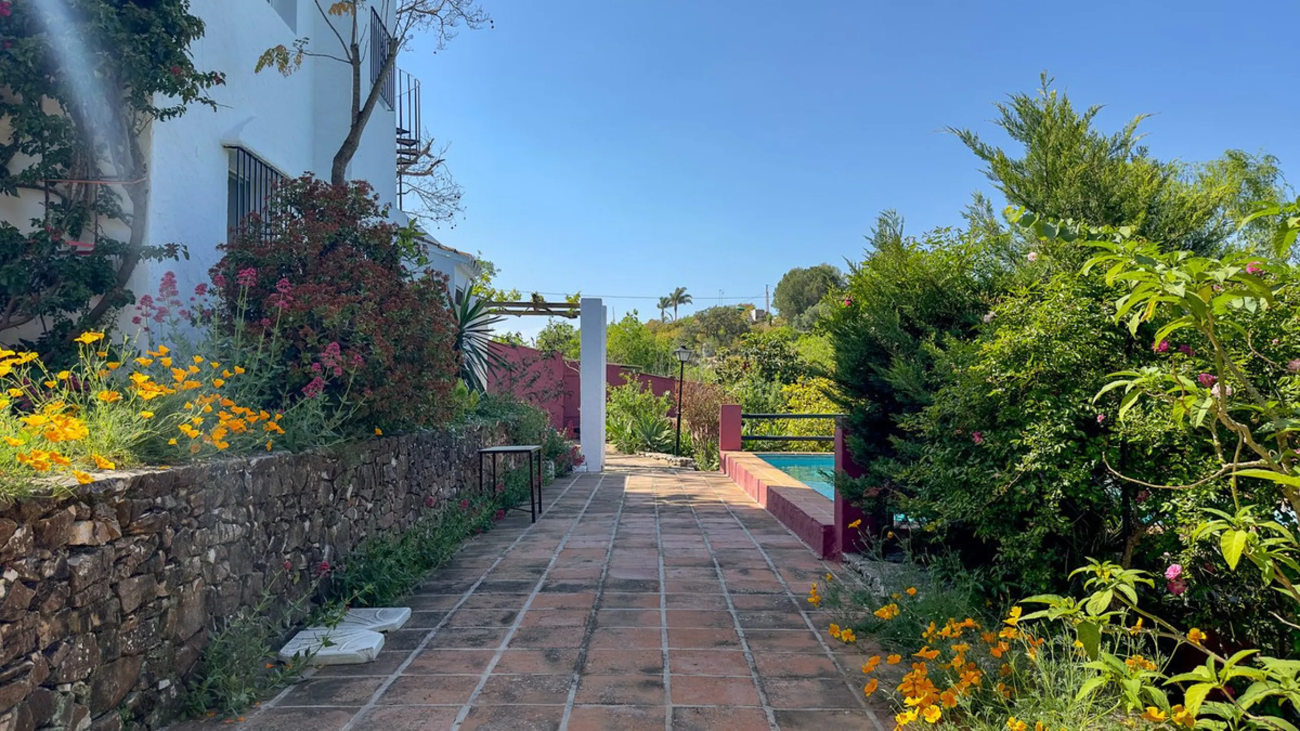 This hidden gem is nestled in a green oasis of nearly 4000m2, located 5 km from the lively village of Alhaurin el Grande, 20 km from the beaches of La Cala de Mijas, and 30 km from Malaga airport. Behind the walls of this historic estate lies a verdant wo