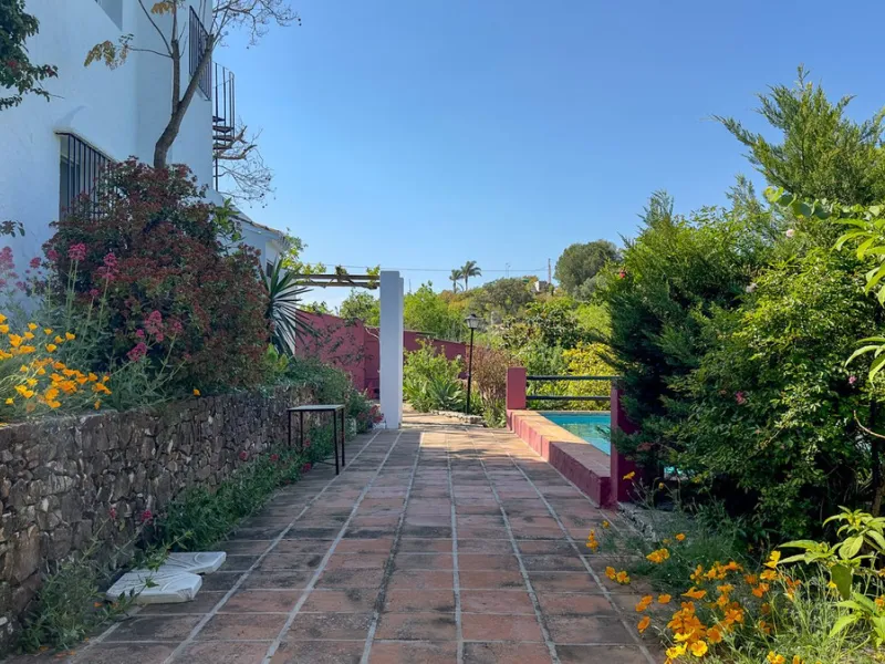 This hidden gem is nestled in a green oasis of nearly 4000m2, located 5 km from the lively village of Alhaurin el Grande, 20 km from the beaches of La Cala de Mijas, and 30 km from Malaga airport. Behind the walls of this historic estate lies a verdant wo