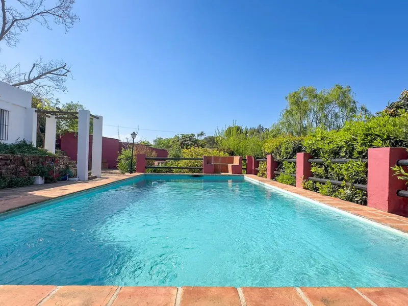 This hidden gem is nestled in a green oasis of nearly 4000m2, located 5 km from the lively village of Alhaurin el Grande, 20 km from the beaches of La Cala de Mijas, and 30 km from Malaga airport. Behind the walls of this historic estate lies a verdant wo