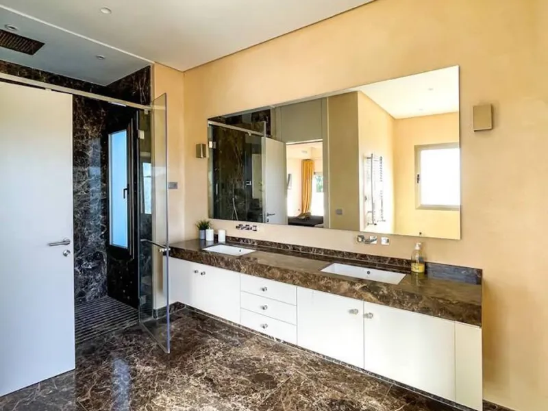 This magnificent villa is an open plan one, and the ground floor flows into the terrace and the garden with lovely sea views and a vast infinity pool, leading to a chill-out area with a fireplace. The villa has ensuite bedrooms on each floor, which gives 
