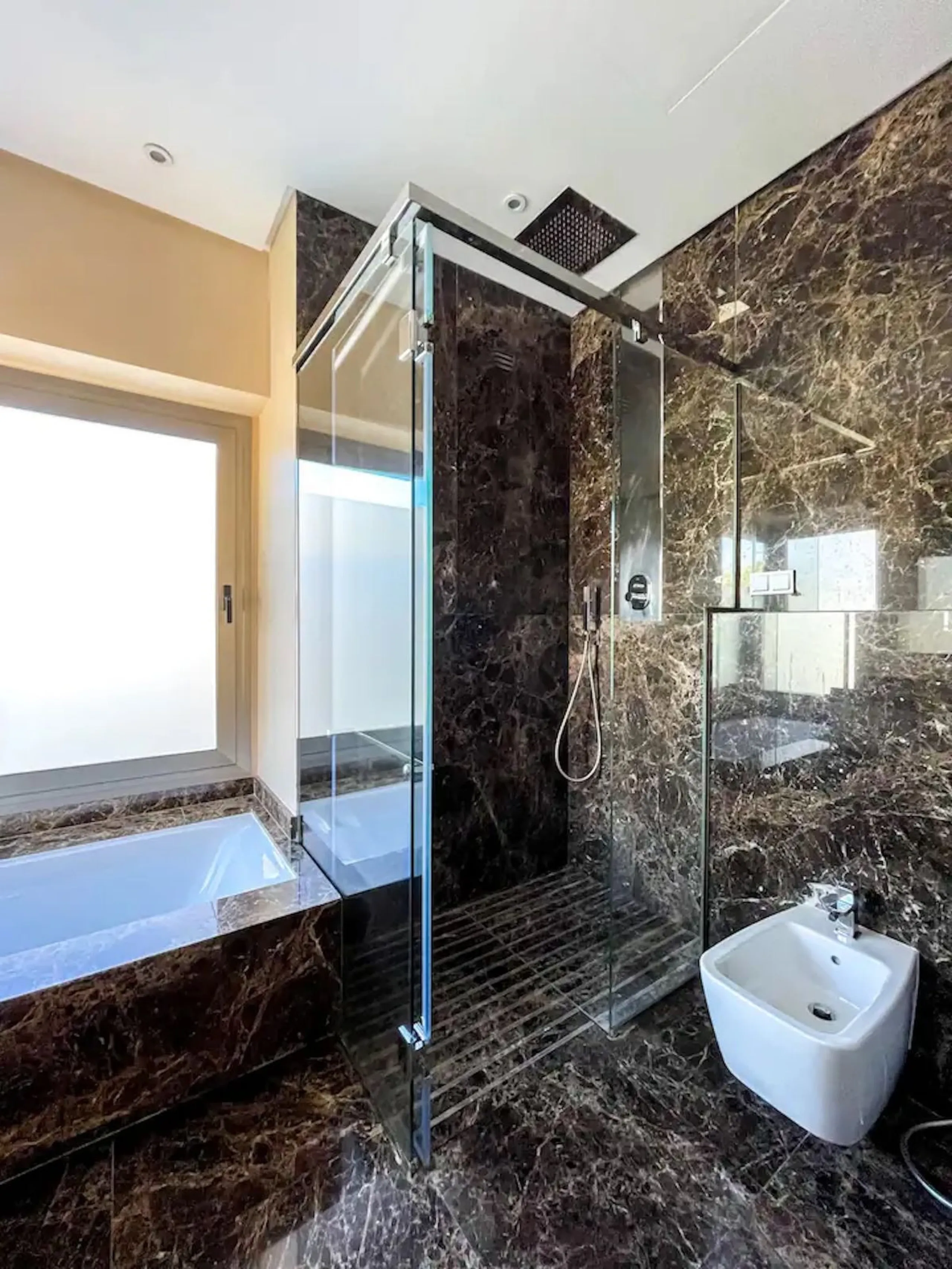 This magnificent villa is an open plan one, and the ground floor flows into the terrace and the garden with lovely sea views and a vast infinity pool, leading to a chill-out area with a fireplace. The villa has ensuite bedrooms on each floor, which gives 