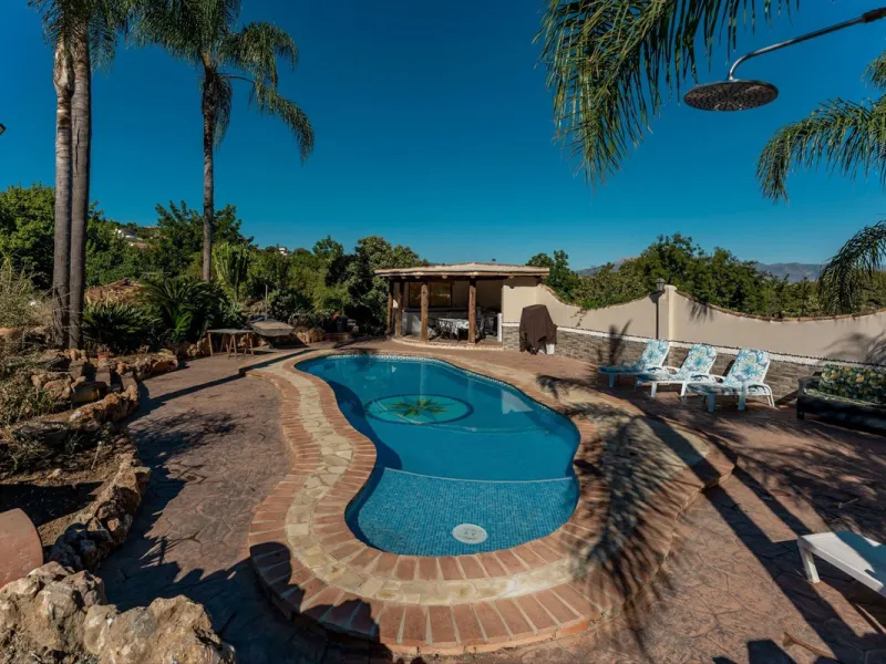 This charming and traditional single-story country property is located just a short drive from the vibrant village of Coín. Set on a private plot of 2,550m², distributed over three terraces, the home enjoys peace, privacy, and lovely countryside surroundi