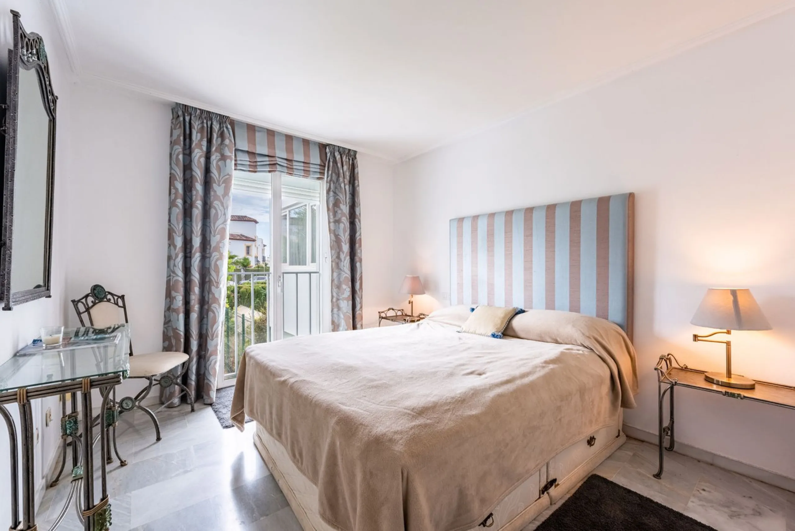 Bright and spacious apartment located in the sought-after Las Jacarandas complex in Bel Air, Estepona. Situated on the first floor, this corner unit enjoys an abundance of natural light and offers tranquil green views with glimpses of the mountains and di