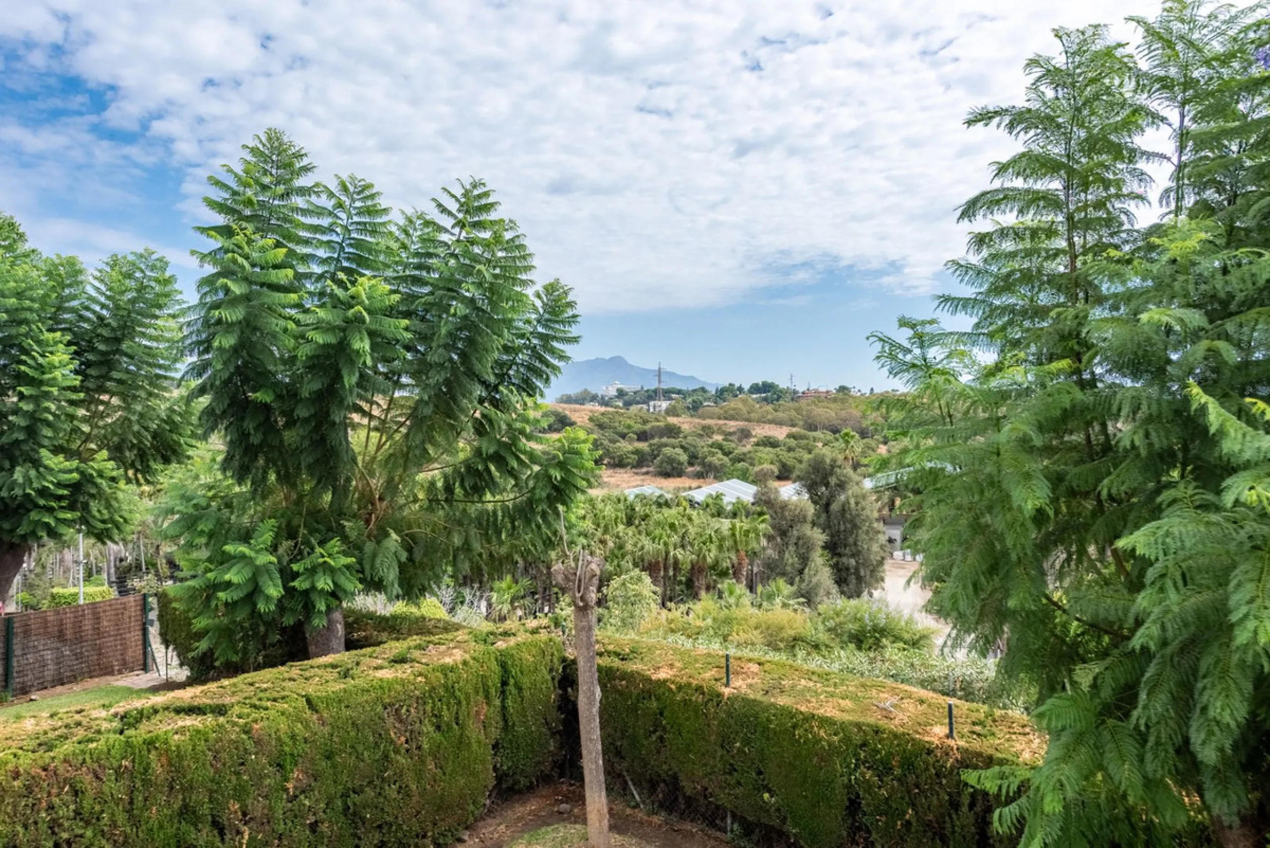 Bright and spacious apartment located in the sought-after Las Jacarandas complex in Bel Air, Estepona. Situated on the first floor, this corner unit enjoys an abundance of natural light and offers tranquil green views with glimpses of the mountains and di