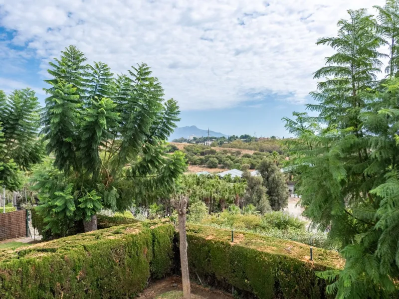 Bright and spacious apartment located in the sought-after Las Jacarandas complex in Bel Air, Estepona. Situated on the first floor, this corner unit enjoys an abundance of natural light and offers tranquil green views with glimpses of the mountains and di