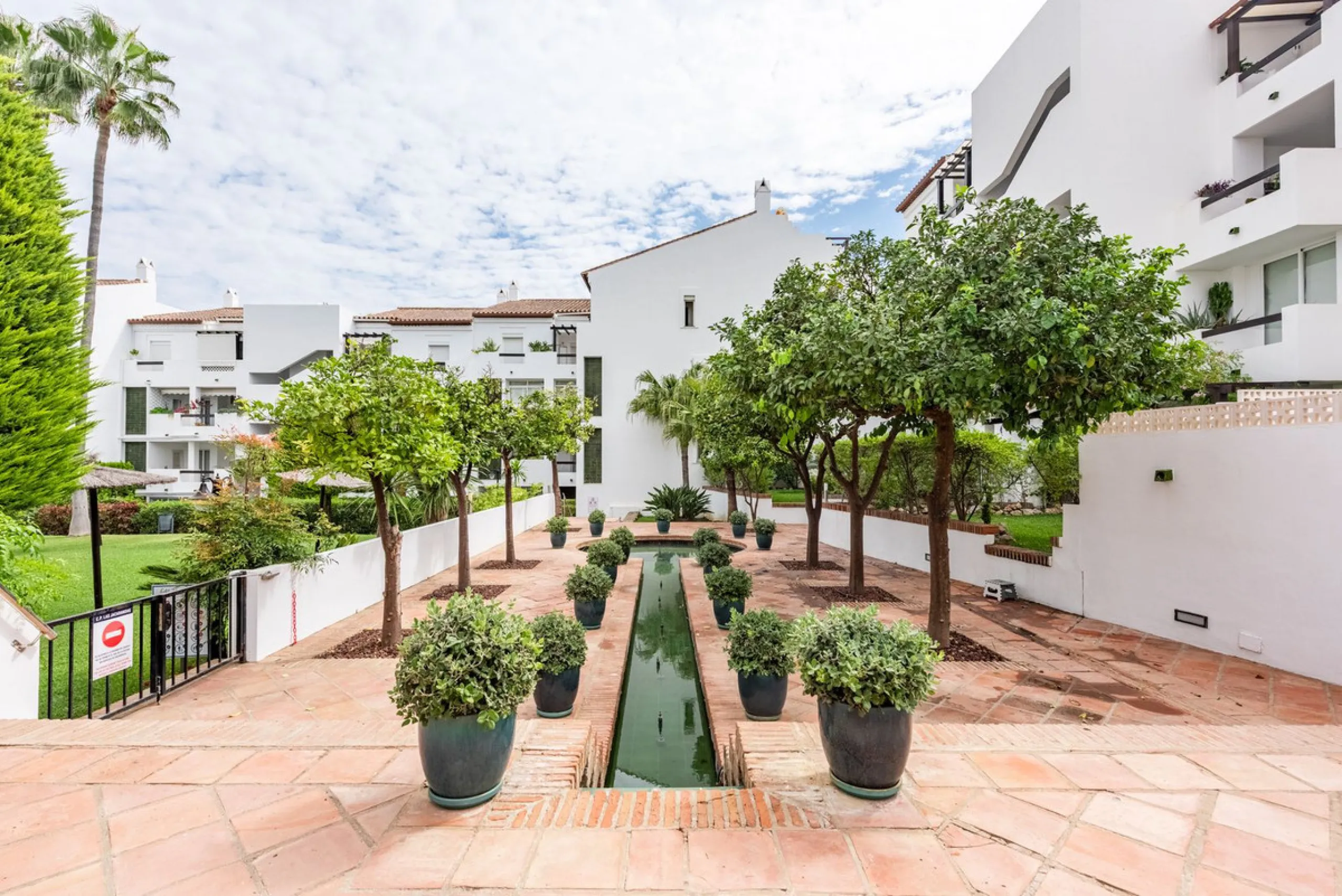 Bright and spacious apartment located in the sought-after Las Jacarandas complex in Bel Air, Estepona. Situated on the first floor, this corner unit enjoys an abundance of natural light and offers tranquil green views with glimpses of the mountains and di