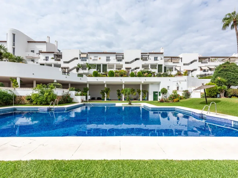 Bright and spacious apartment located in the sought-after Las Jacarandas complex in Bel Air, Estepona. Situated on the first floor, this corner unit enjoys an abundance of natural light and offers tranquil green views with glimpses of the mountains and di