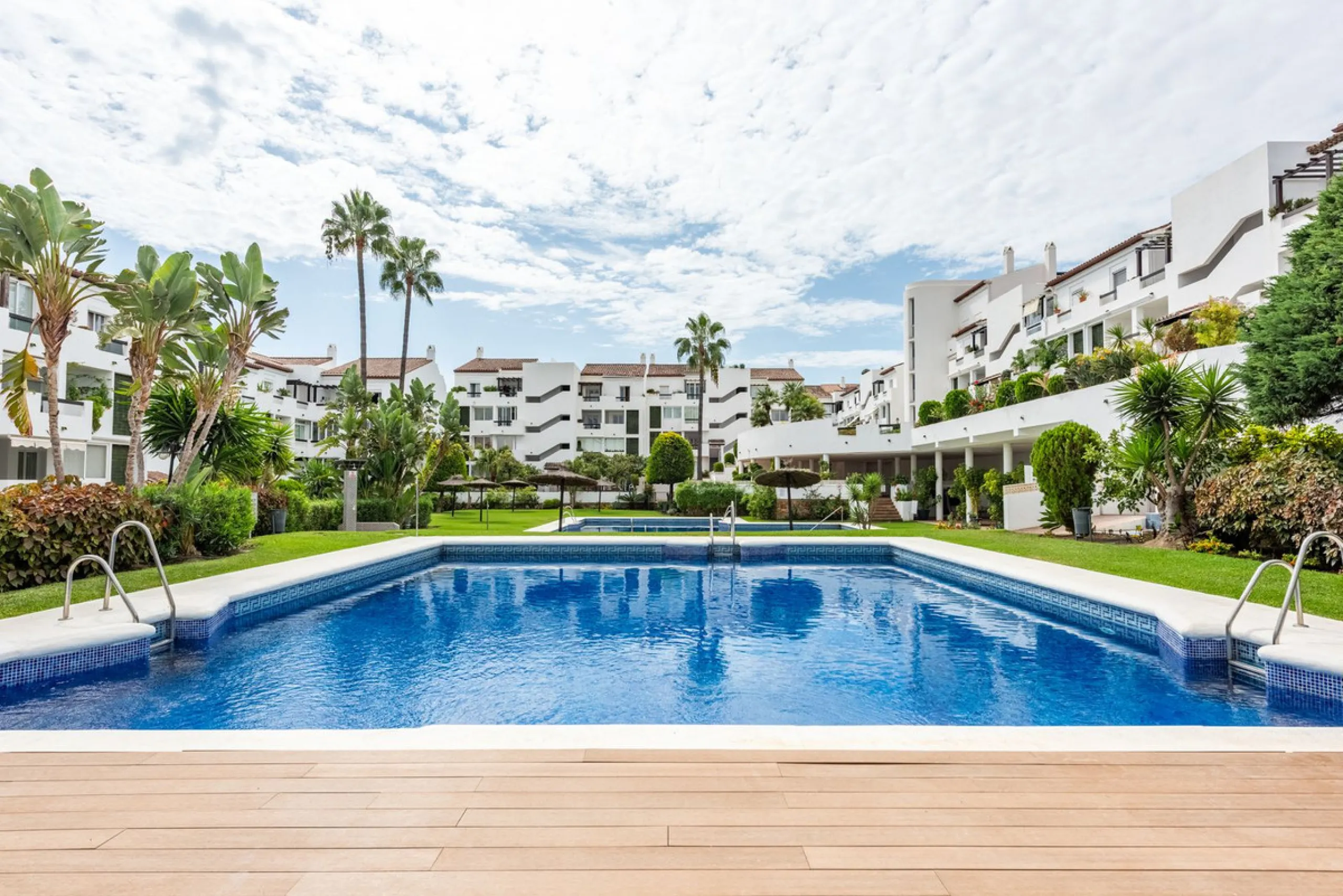 Bright and spacious apartment located in the sought-after Las Jacarandas complex in Bel Air, Estepona. Situated on the first floor, this corner unit enjoys an abundance of natural light and offers tranquil green views with glimpses of the mountains and di