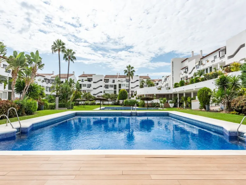 Bright and spacious apartment located in the sought-after Las Jacarandas complex in Bel Air, Estepona. Situated on the first floor, this corner unit enjoys an abundance of natural light and offers tranquil green views with glimpses of the mountains and di