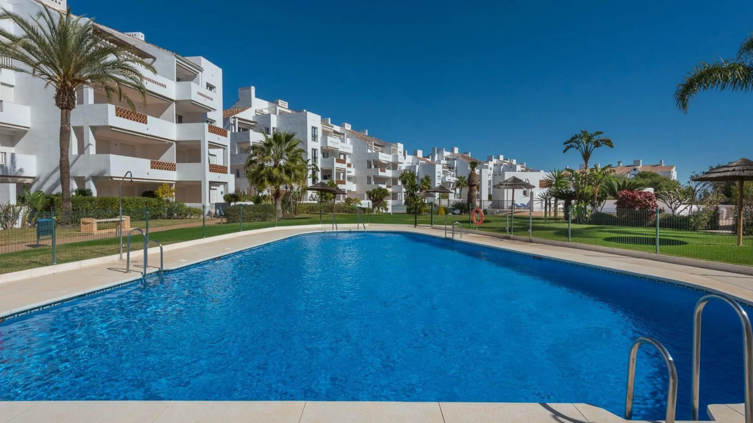 JUST REDUCED .LUXURY GROUND FLOOR GATED COMMUNITY. FRONT LINE GOLF. 2 BED 2 BATH APARTMENT MIRAFLORES. € 299,950 WITH EXISTING TOURIST LICENCE.
