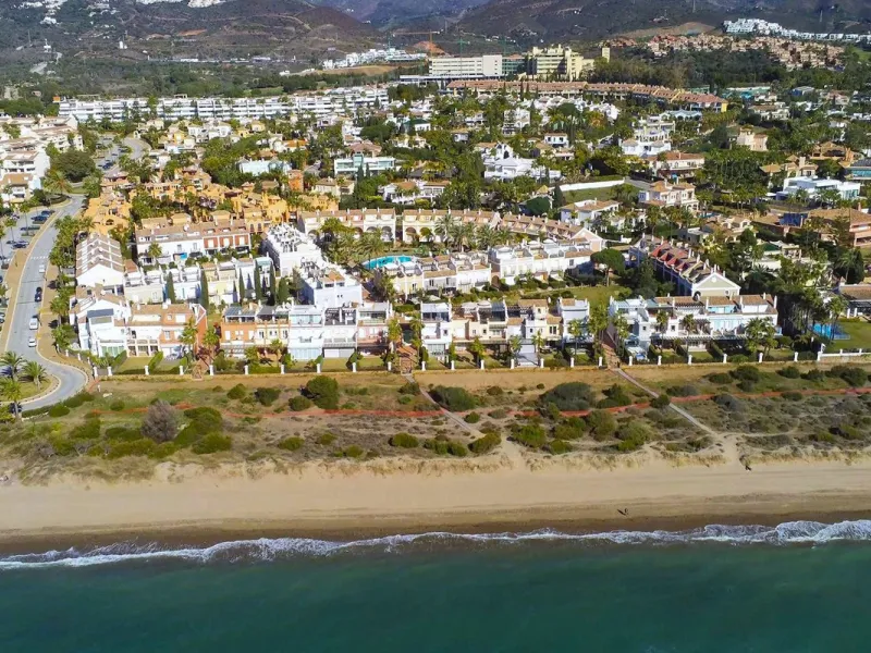 Nestled within one of Bahía de Marbella's most sought-after beachfront urbanizations, this stunning townhouse offers an unparalleled coastal living experience. Imagine waking up to the sound of the waves and having direct, private access to the golden san