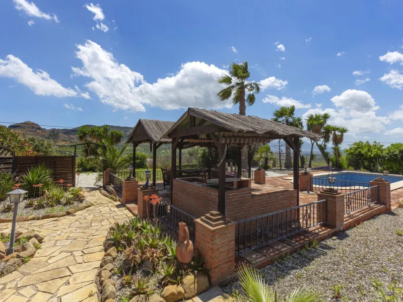This finca set in an elevated position has impressive mountain views all around it.  The garden is split into different areas each with its own beautiful vibe. Stylish barbecue area by the pool is great for relaxing and welcoming guests.  Main house has t