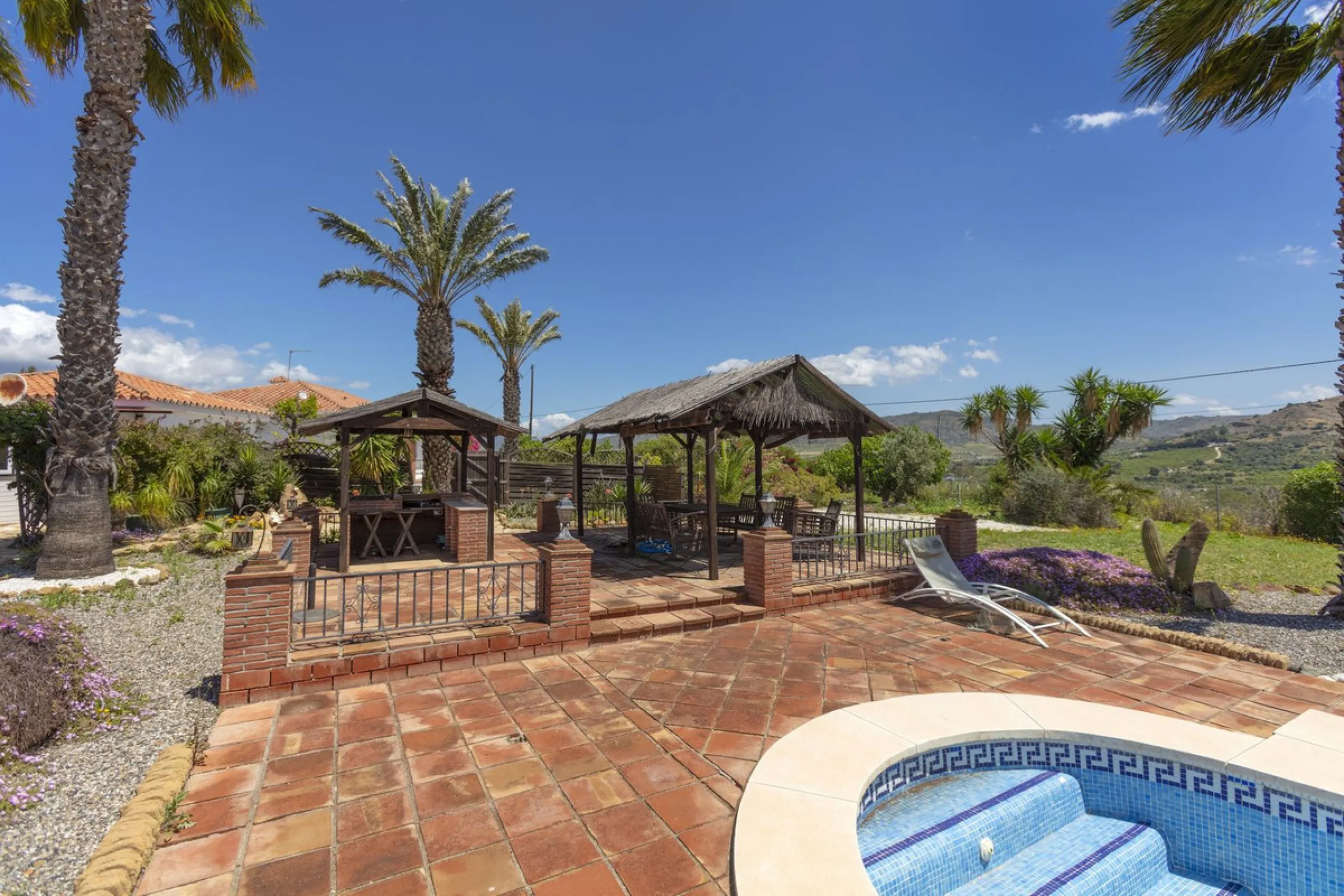 This finca set in an elevated position has impressive mountain views all around it.  The garden is split into different areas each with its own beautiful vibe. Stylish barbecue area by the pool is great for relaxing and welcoming guests.  Main house has t