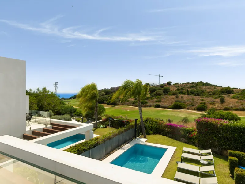 This stunning semi-detached villa offers panoramic views of the Mediterranean Sea and the lush Cabopino Golf Course, set within the exclusive gated community of Green Hill Marbella. Surrounded by rolling Andalusian hills, the home blends sleek modern desi
