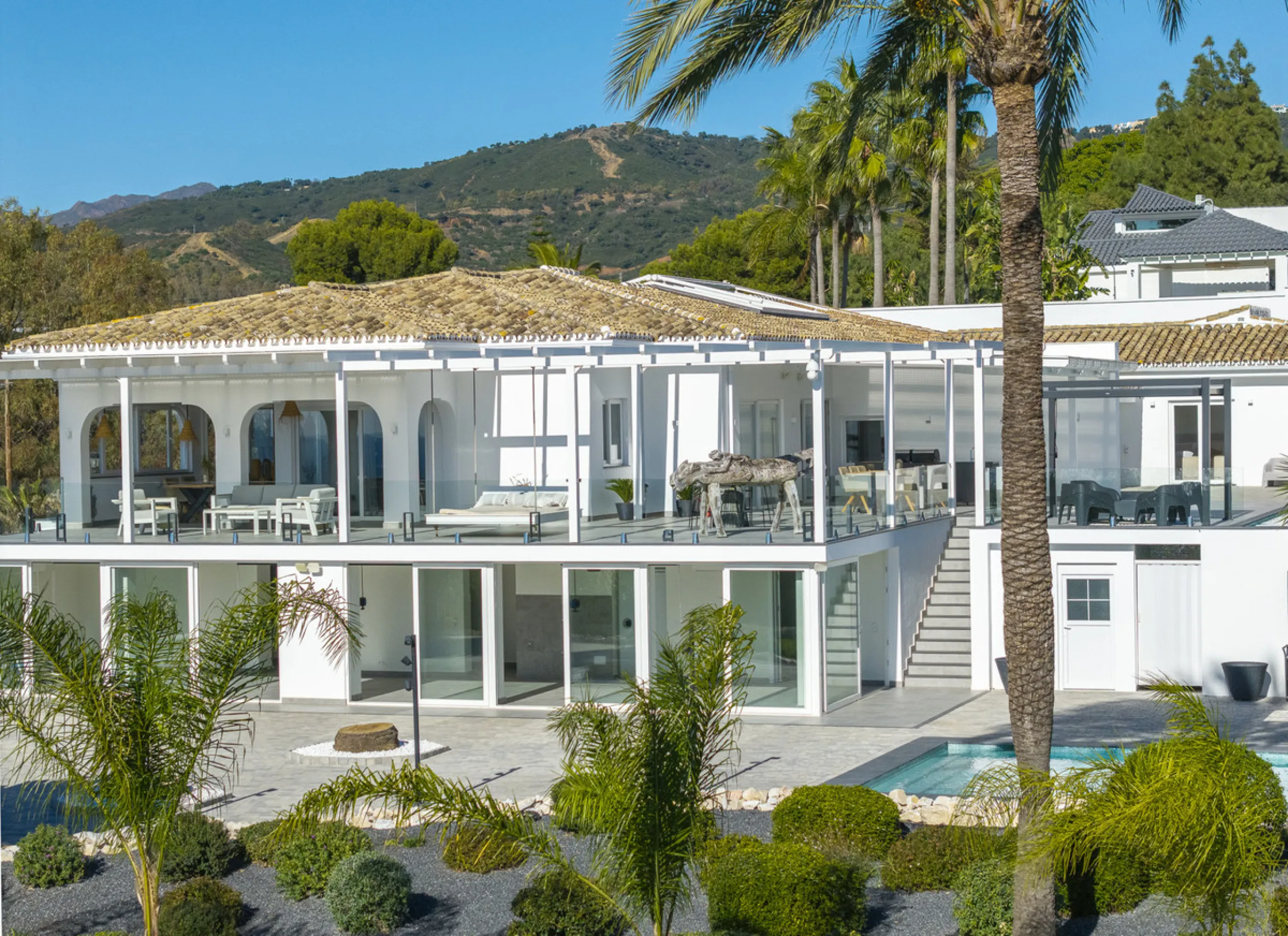 Set on two generous plots totalling 6.128 m², this private and peaceful luxury villa offers a rare blend of modern Mediterranean style and natural beauty in Elviria, Marbella East. Surrounded by its own unspoilt land on one side, the property enjoys excep