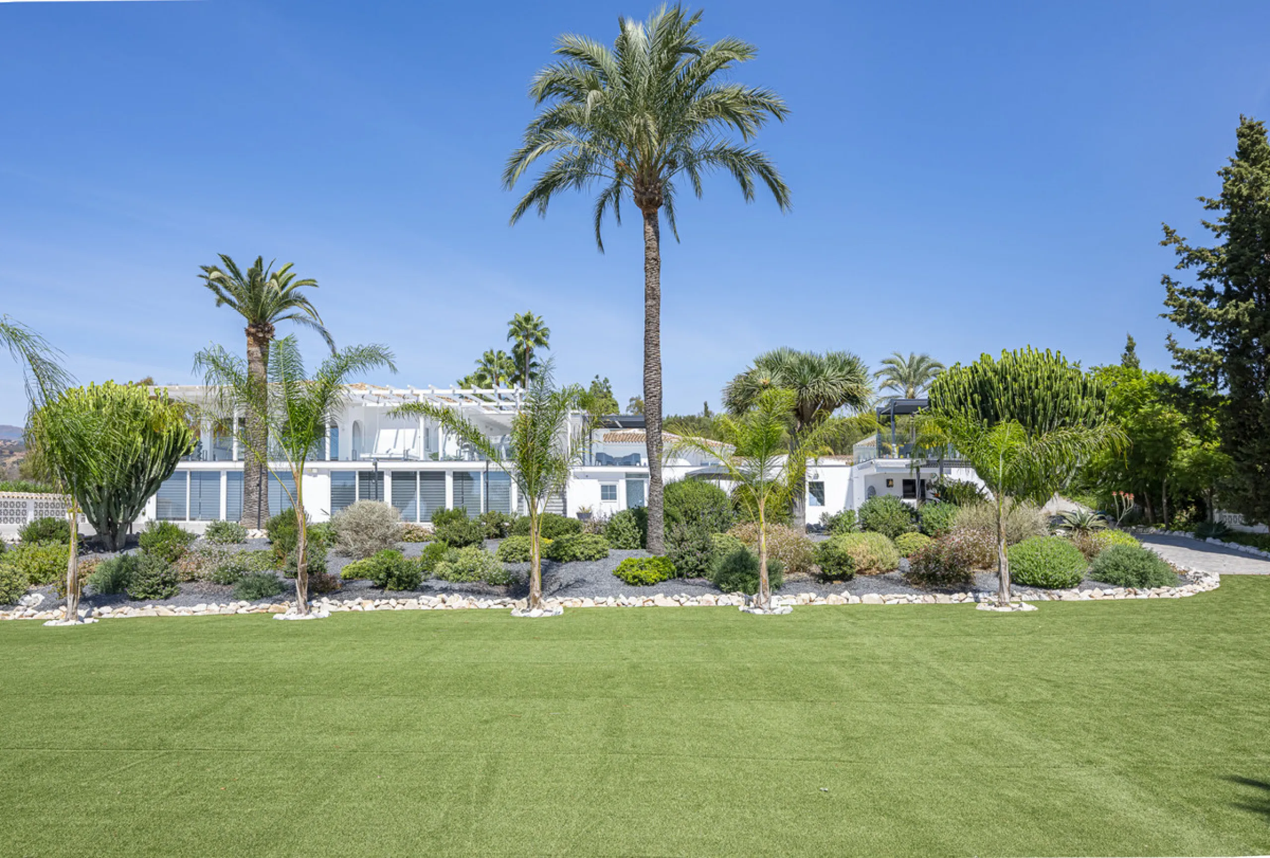 Set on two generous plots totalling 6.128 m², this private and peaceful luxury villa offers a rare blend of modern Mediterranean style and natural beauty in Elviria, Marbella East. Surrounded by its own unspoilt land on one side, the property enjoys excep