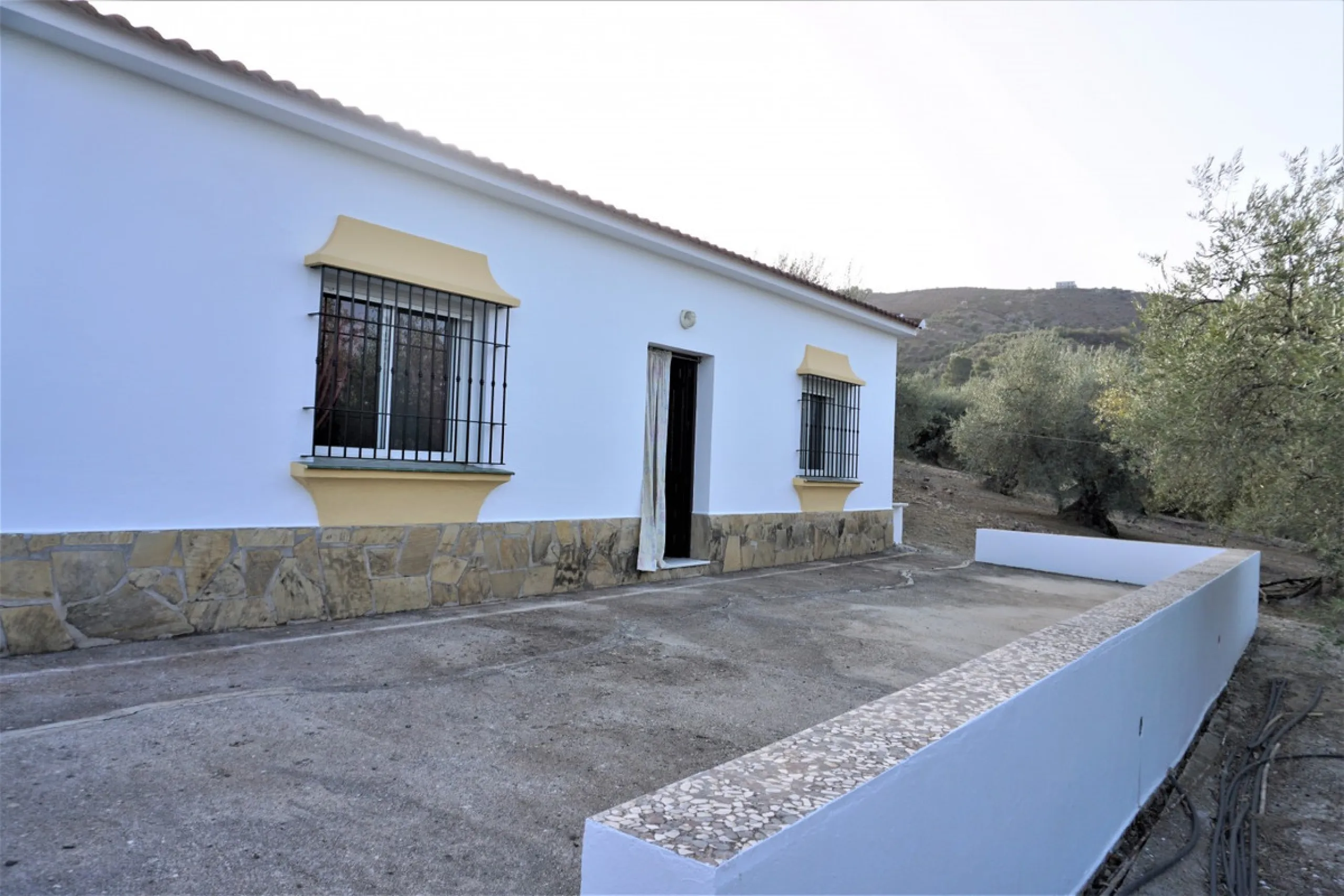 Just outside Alcaucin and within walking distance of the village you can find this finca with a well-maintained country house of 121 m2. In front of the house there ́s a spacious terrace overlooking the olive grove of a 130 olive trees and other fruit tre