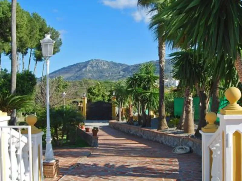 Andalusian Villa located on a plot of 12,000 square meters. With a 3000 m2 garden, mature with some trees over 100 years old, close to schools and shops, with easy access to the highway and close to Malaga airport.
