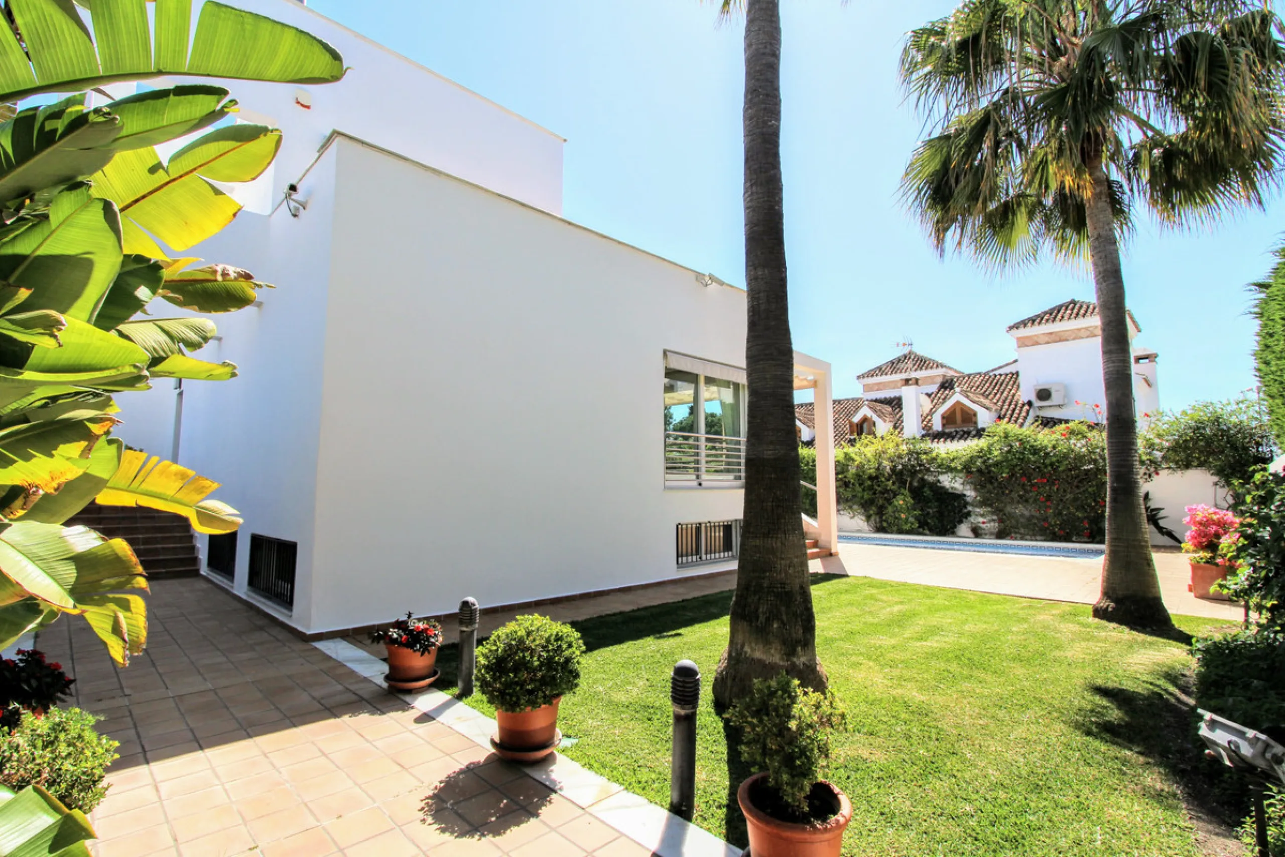 Spacious beachside villa in popular San Pedro, a short drive west of Marbella and Puerto Banús, and within walking distance of the beach promenade, shops and restaurants. This house is set in manicured gardens with a swimming pool, offering a perfect comb