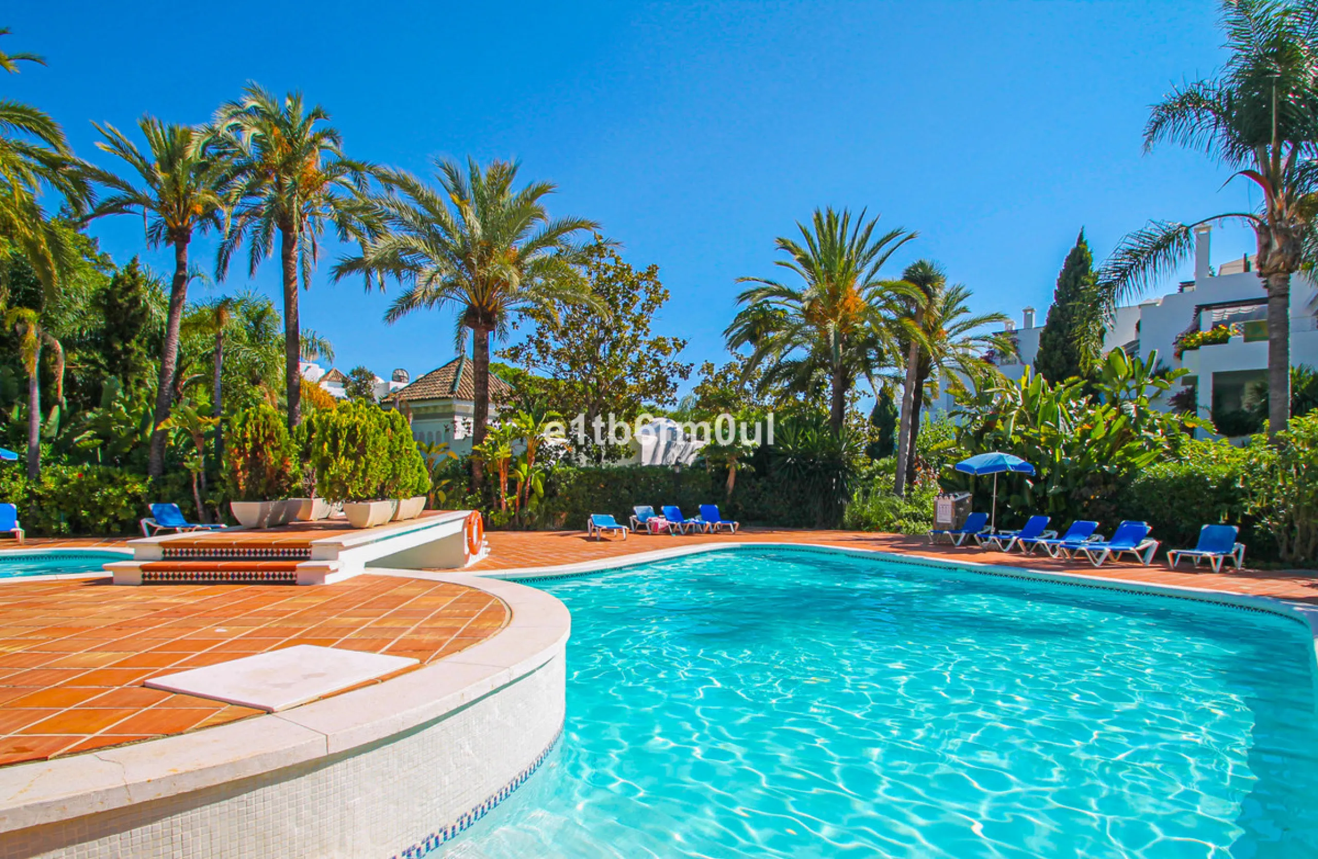 BEACHSIDE • WALKING DISTANCE TO MARBELLA CENTRE & ALL AMENITIES • Cheerful corner ground floor two bedroom apartment just steps from the beach. Located in a very desirable complex with lush mature gardens and swimming pool, right on the promenade, just a 