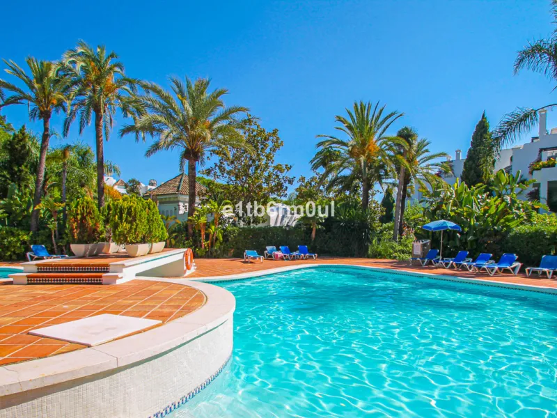 BEACHSIDE • WALKING DISTANCE TO MARBELLA CENTRE & ALL AMENITIES • Cheerful corner ground floor two bedroom apartment just steps from the beach. Located in a very desirable complex with lush mature gardens and swimming pool, right on the promenade, just a 