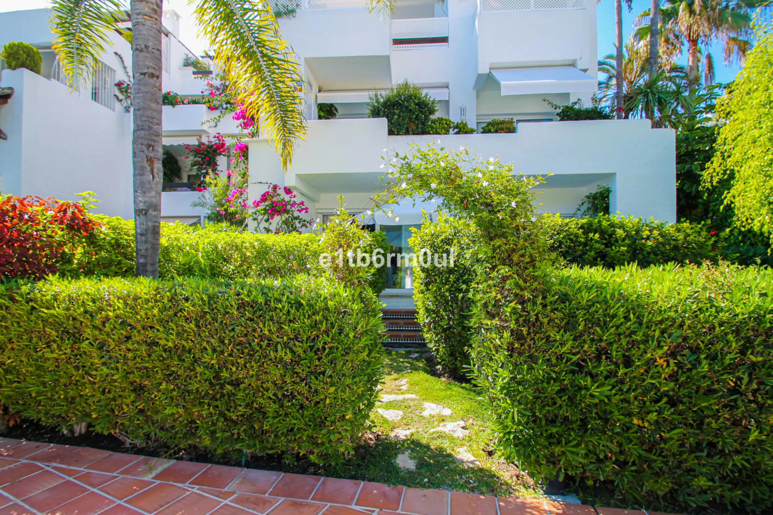 BEACHSIDE • WALKING DISTANCE TO MARBELLA CENTRE & ALL AMENITIES • Cheerful corner ground floor two bedroom apartment just steps from the beach. Located in a very desirable complex with lush mature gardens and swimming pool, right on the promenade, just a 