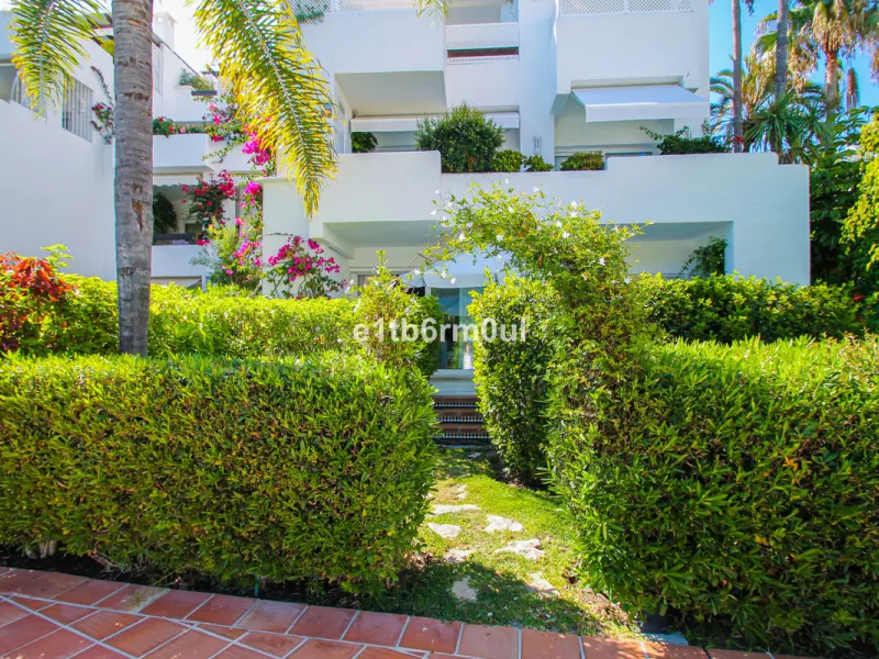 BEACHSIDE • WALKING DISTANCE TO MARBELLA CENTRE & ALL AMENITIES • Cheerful corner ground floor two bedroom apartment just steps from the beach. Located in a very desirable complex with lush mature gardens and swimming pool, right on the promenade, just a 