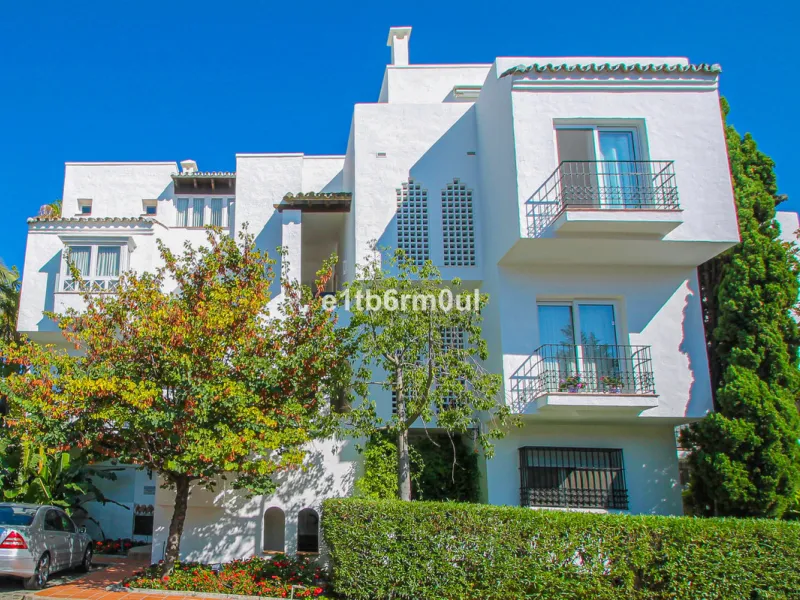 BEACHSIDE • WALKING DISTANCE TO MARBELLA CENTRE & ALL AMENITIES • Cheerful corner ground floor two bedroom apartment just steps from the beach. Located in a very desirable complex with lush mature gardens and swimming pool, right on the promenade, just a 