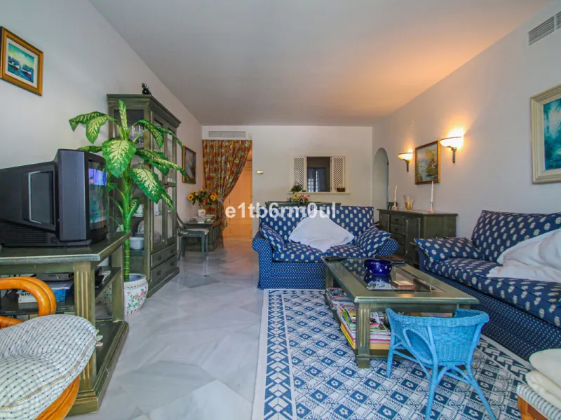 BEACHSIDE • WALKING DISTANCE TO MARBELLA CENTRE & ALL AMENITIES • Cheerful corner ground floor two bedroom apartment just steps from the beach. Located in a very desirable complex with lush mature gardens and swimming pool, right on the promenade, just a 