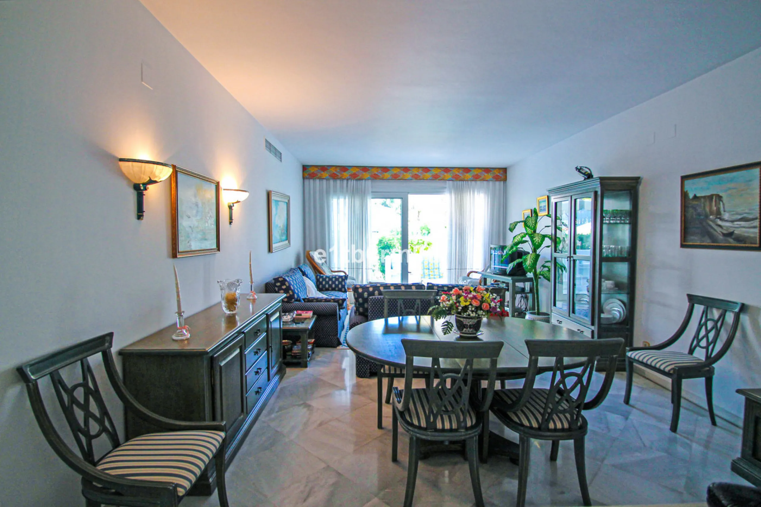BEACHSIDE • WALKING DISTANCE TO MARBELLA CENTRE & ALL AMENITIES • Cheerful corner ground floor two bedroom apartment just steps from the beach. Located in a very desirable complex with lush mature gardens and swimming pool, right on the promenade, just a 