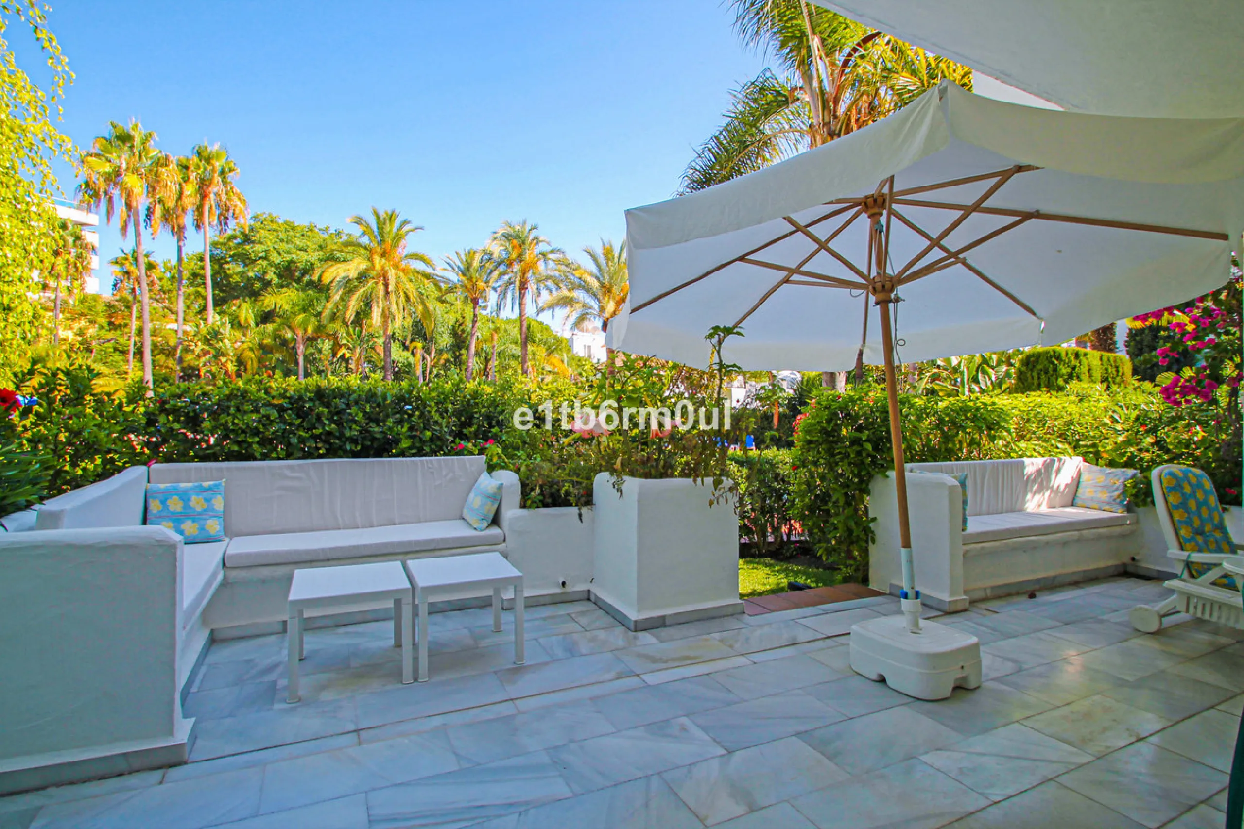BEACHSIDE • WALKING DISTANCE TO MARBELLA CENTRE & ALL AMENITIES • Cheerful corner ground floor two bedroom apartment just steps from the beach. Located in a very desirable complex with lush mature gardens and swimming pool, right on the promenade, just a 