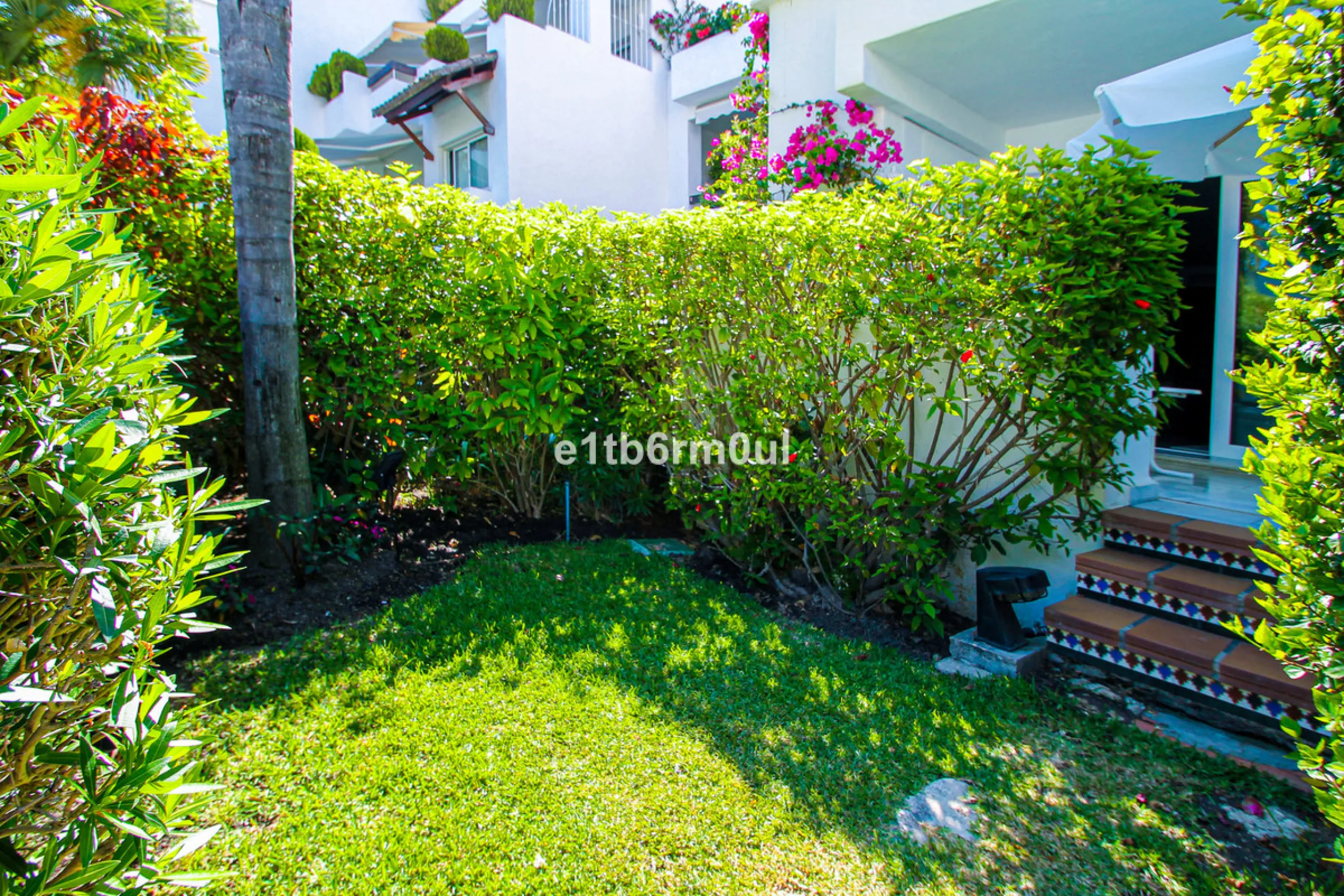BEACHSIDE • WALKING DISTANCE TO MARBELLA CENTRE & ALL AMENITIES • Cheerful corner ground floor two bedroom apartment just steps from the beach. Located in a very desirable complex with lush mature gardens and swimming pool, right on the promenade, just a 