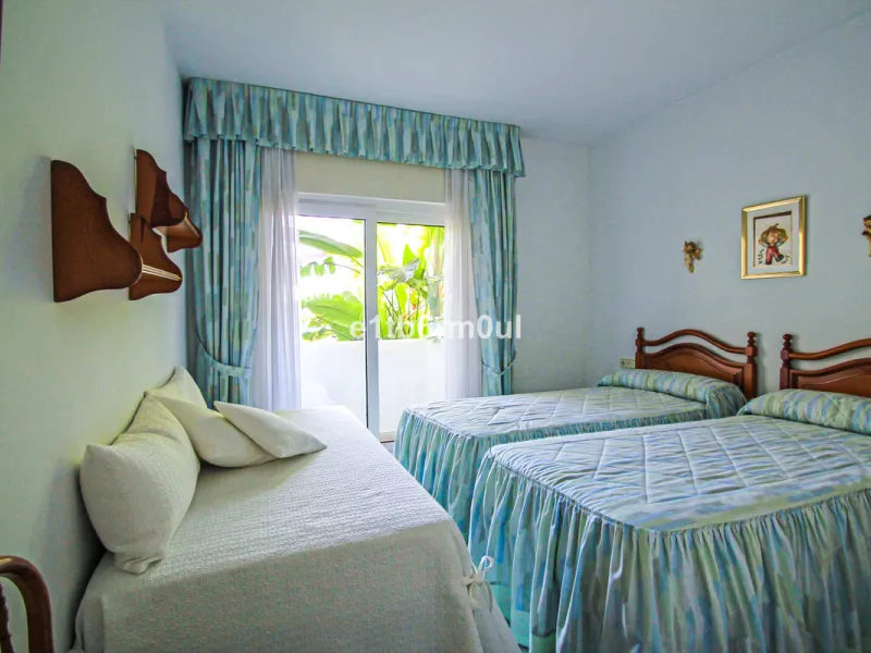 BEACHSIDE • WALKING DISTANCE TO MARBELLA CENTRE & ALL AMENITIES • Cheerful corner ground floor two bedroom apartment just steps from the beach. Located in a very desirable complex with lush mature gardens and swimming pool, right on the promenade, just a 