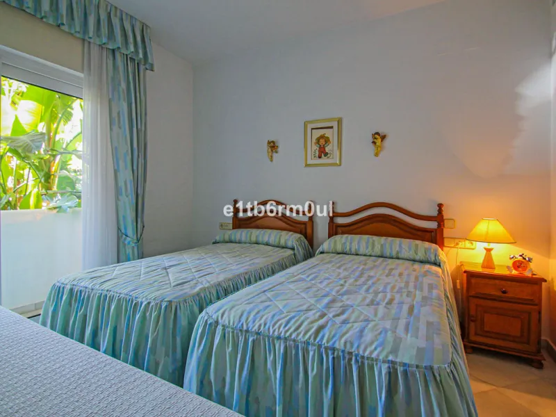 BEACHSIDE • WALKING DISTANCE TO MARBELLA CENTRE & ALL AMENITIES • Cheerful corner ground floor two bedroom apartment just steps from the beach. Located in a very desirable complex with lush mature gardens and swimming pool, right on the promenade, just a 