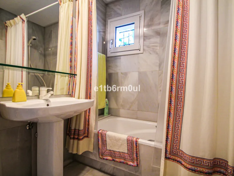 BEACHSIDE • WALKING DISTANCE TO MARBELLA CENTRE & ALL AMENITIES • Cheerful corner ground floor two bedroom apartment just steps from the beach. Located in a very desirable complex with lush mature gardens and swimming pool, right on the promenade, just a 