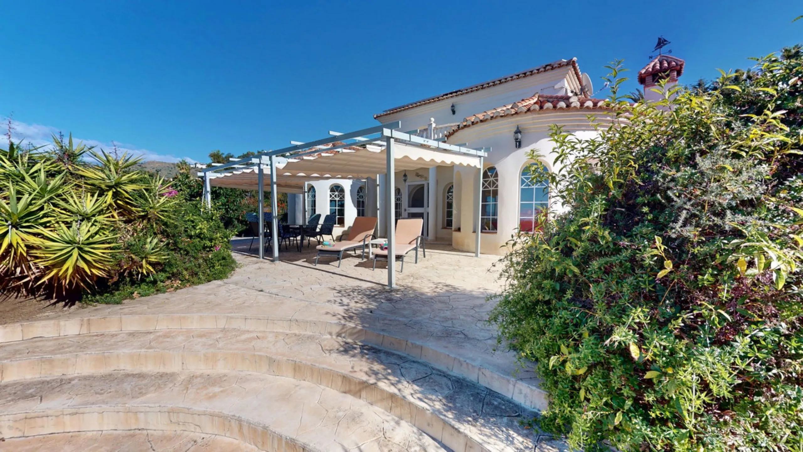 This elegant villa in Arenas, Málaga, offers a harmonious blend of space and style across two levels. The residence boasts four bedrooms and three bathrooms, with the primary bedroom providing generous personal space. The ground floor houses the main livi