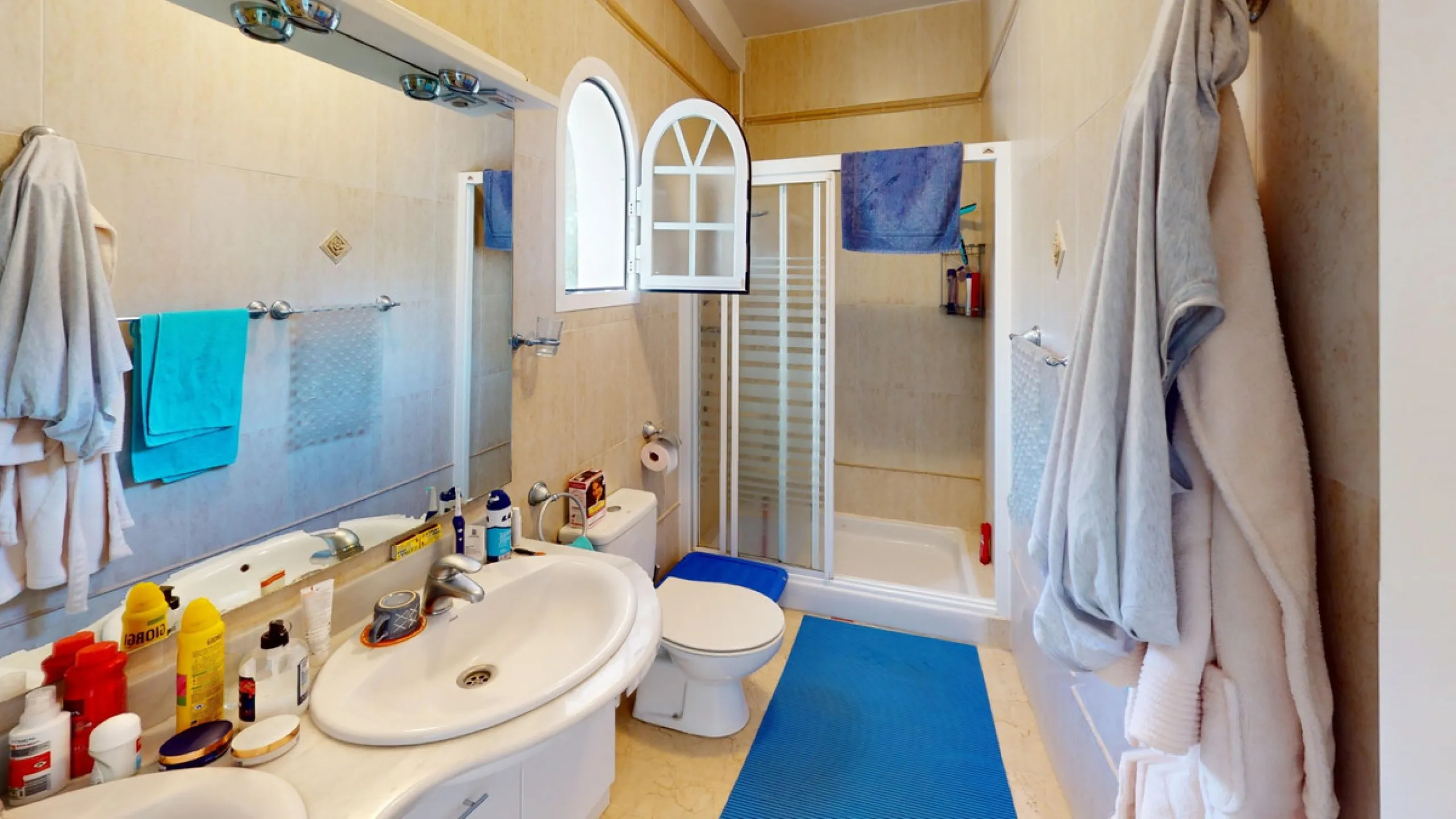 This elegant villa in Arenas, Málaga, offers a harmonious blend of space and style across two levels. The residence boasts four bedrooms and three bathrooms, with the primary bedroom providing generous personal space. The ground floor houses the main livi