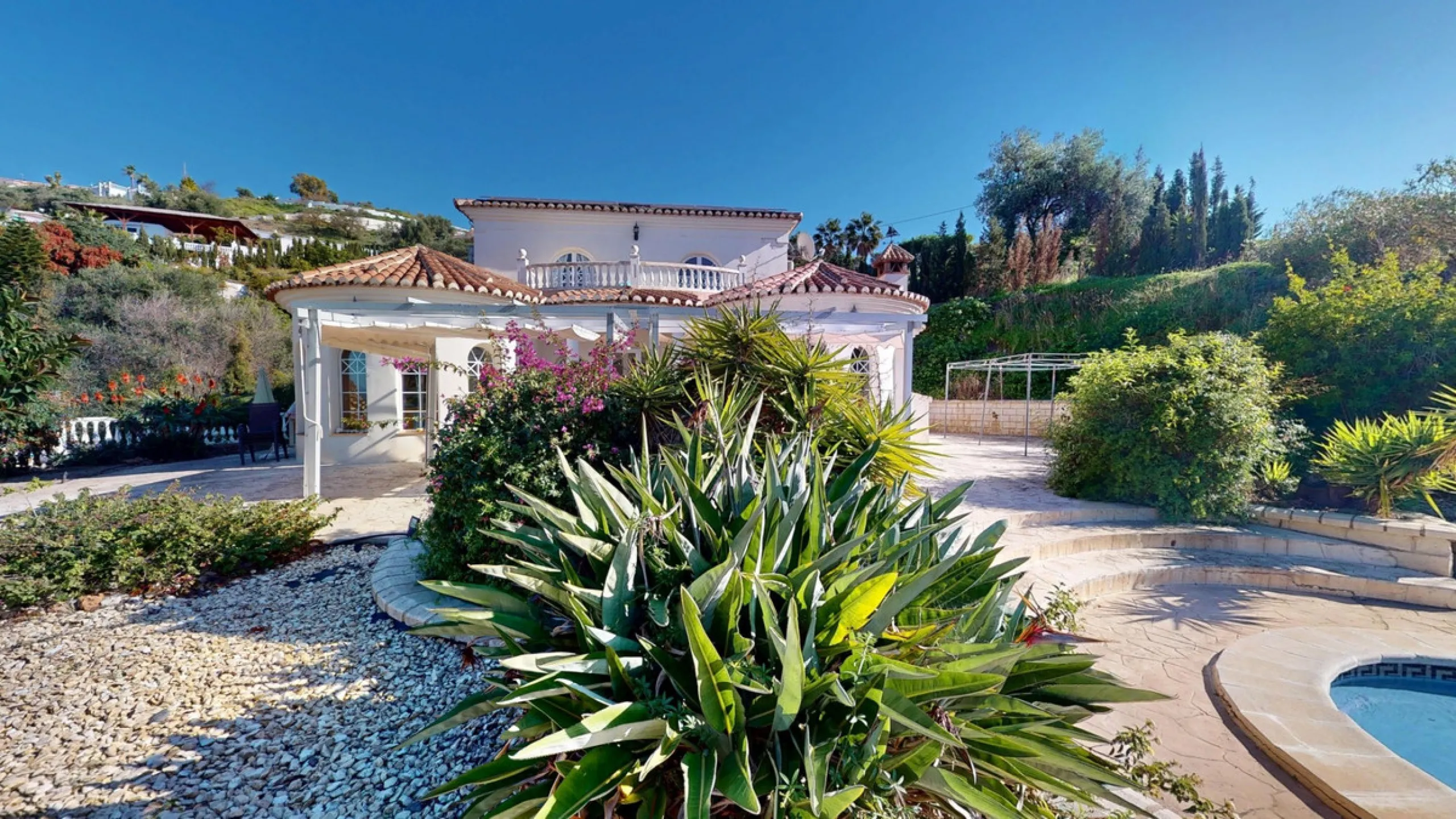 This elegant villa in Arenas, Málaga, offers a harmonious blend of space and style across two levels. The residence boasts four bedrooms and three bathrooms, with the primary bedroom providing generous personal space. The ground floor houses the main livi