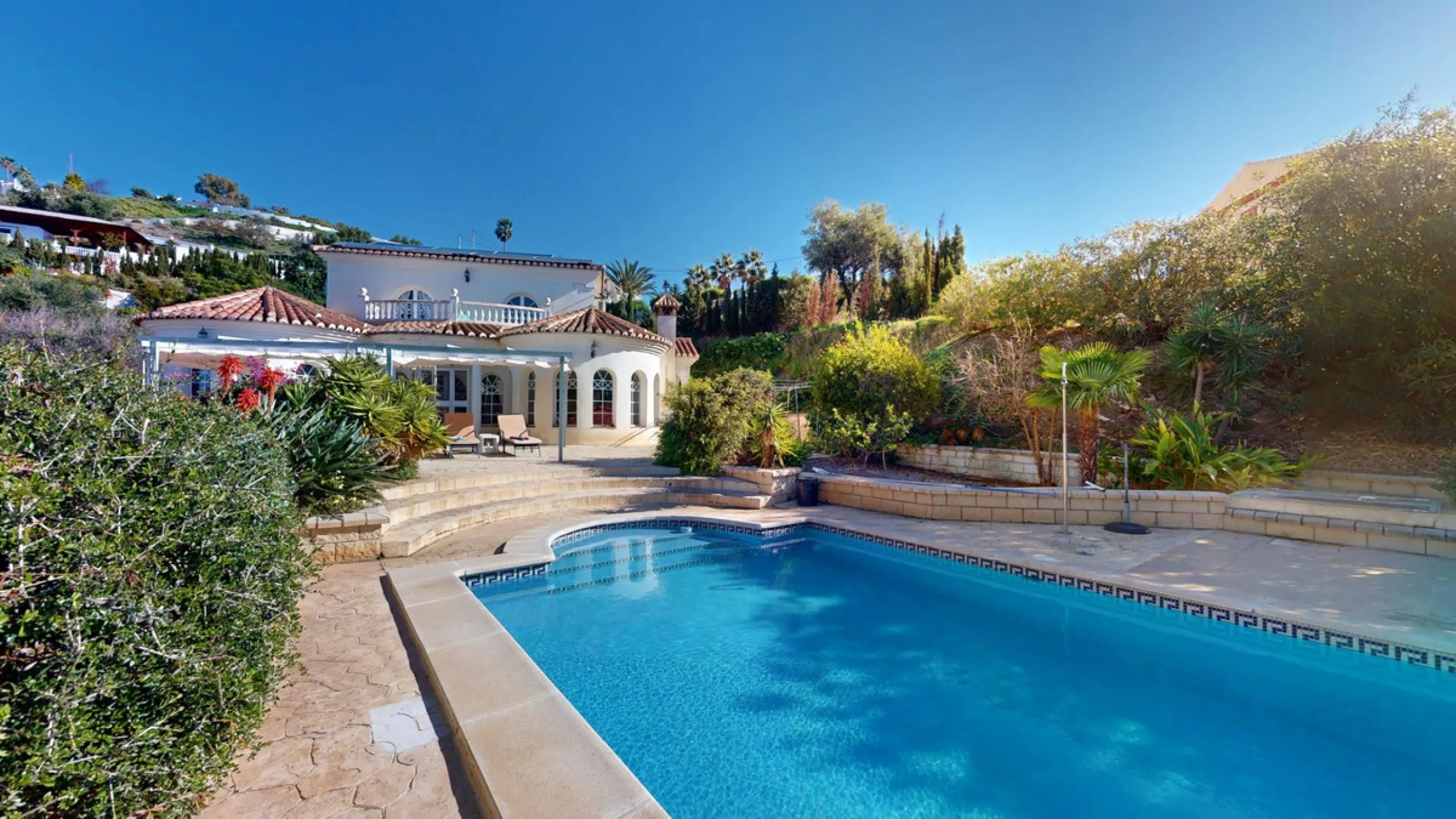 This elegant villa in Arenas, Málaga, offers a harmonious blend of space and style across two levels. The residence boasts four bedrooms and three bathrooms, with the primary bedroom providing generous personal space. The ground floor houses the main livi