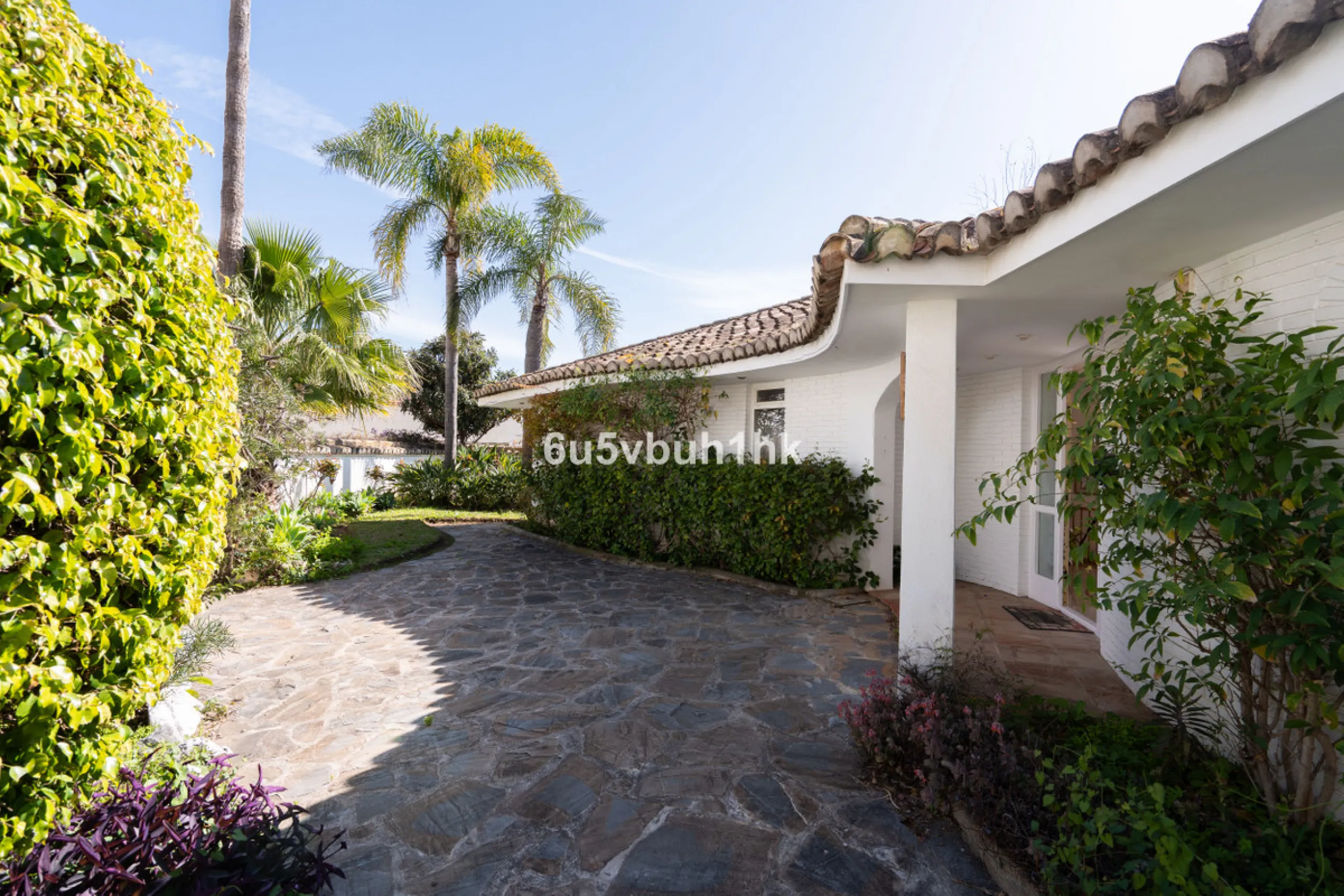 Hidden among palm trees and mature gardens in the established residential area of Sitio de Calahonda, this beautiful Andalusian villa captures the essence of traditional Mediterranean living. From the moment you arrive through the private gated entrance a