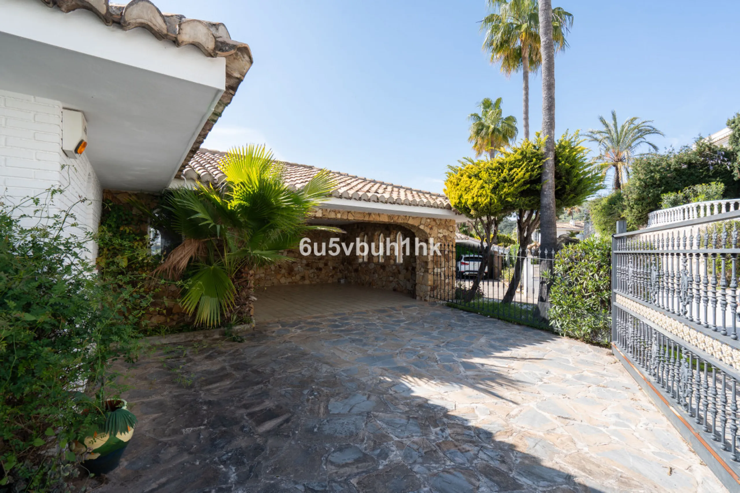 Hidden among palm trees and mature gardens in the established residential area of Sitio de Calahonda, this beautiful Andalusian villa captures the essence of traditional Mediterranean living. From the moment you arrive through the private gated entrance a
