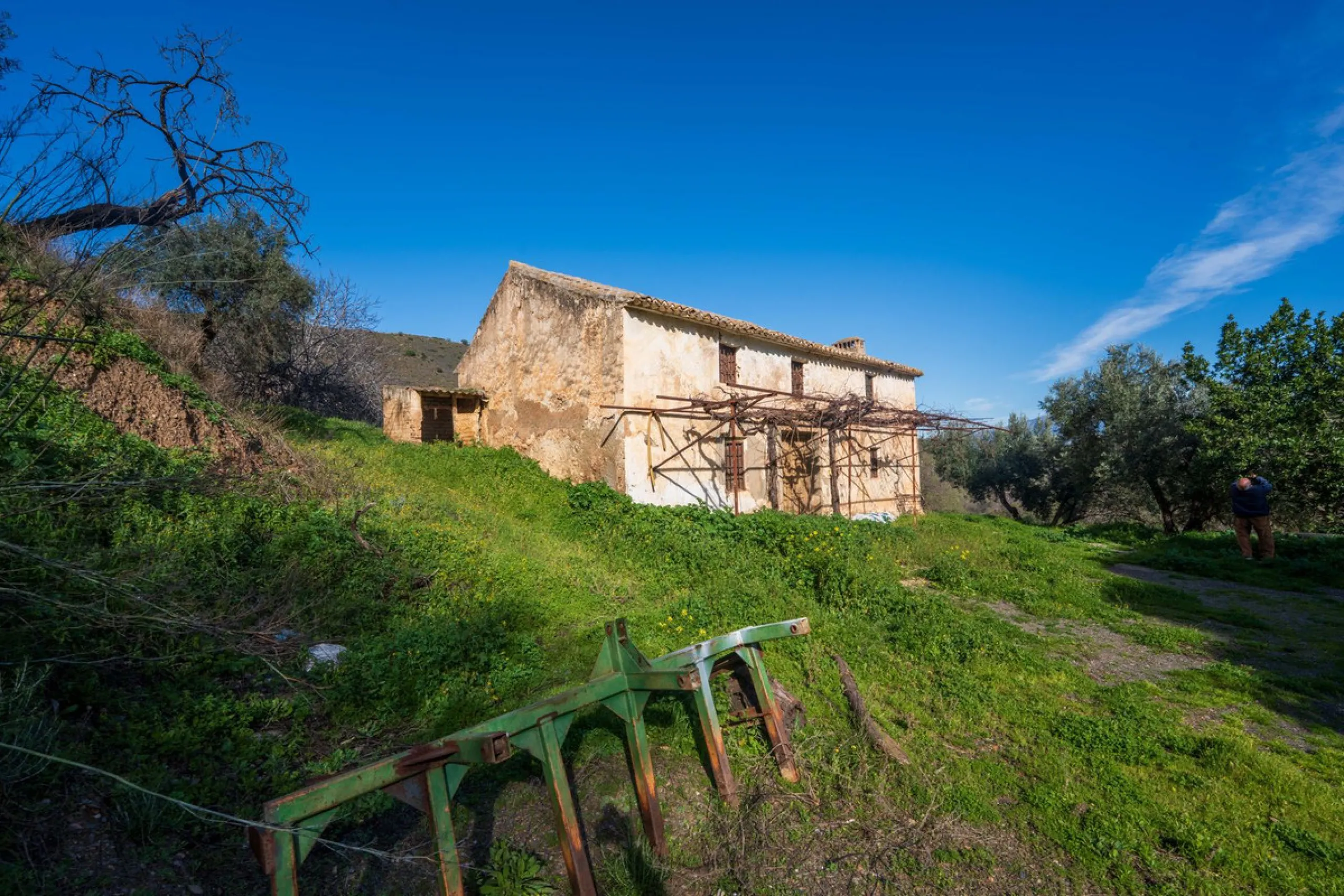 Imagine a place where time seems to stand still—a vast, quiet estate that breathes history in every corner. Two old houses in ruins rise gently from the land, their weathered walls worn by the years yet still standing strong, as if waiting for someone to 
