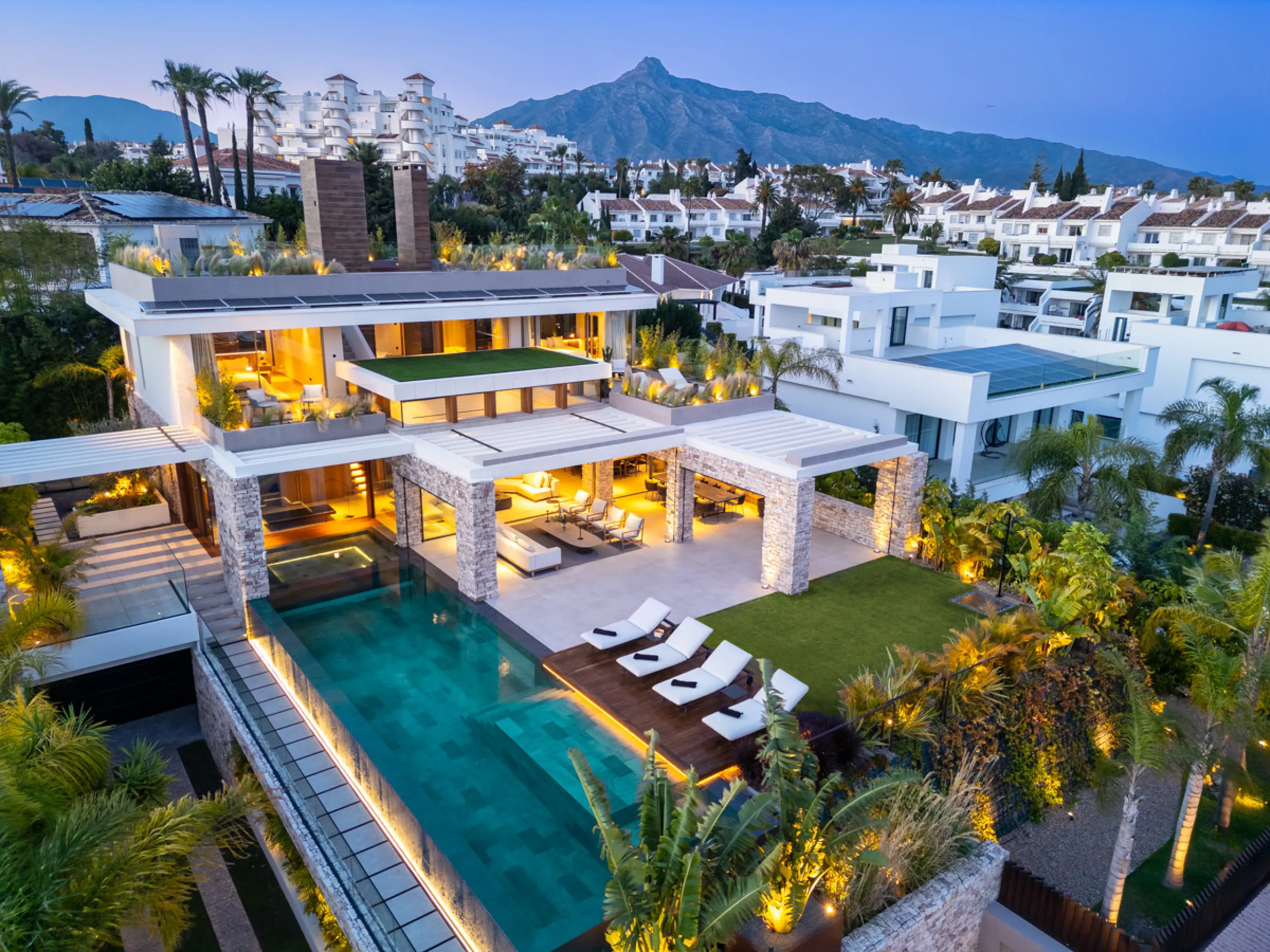 Nestled gracefully upon the verdant slopes of Nueva Andalucía, this villa is a triumph of modern elegance and luxurious design, an embodiment of serene sophistication. As you approach the property, you are greeted by a grand entrance framed by sleek lines